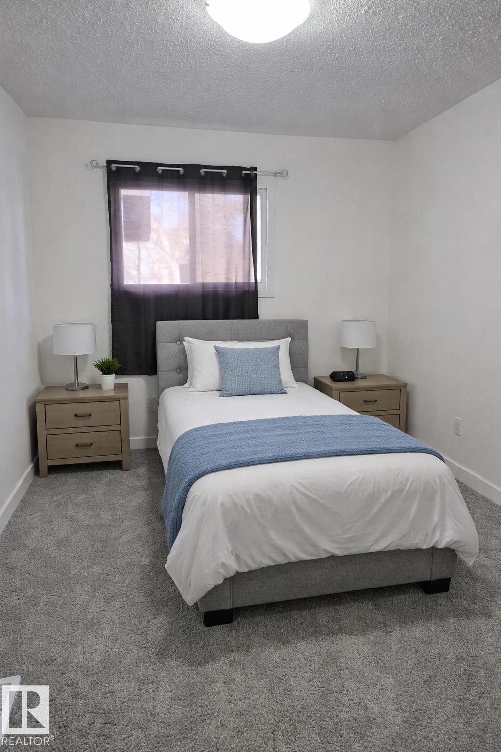 Carpeted bedroom with baseboards and a textured ceiling - 4513 53 Avenue, Wetaskiwin, AB - Indoor Photo Showing Bedroom