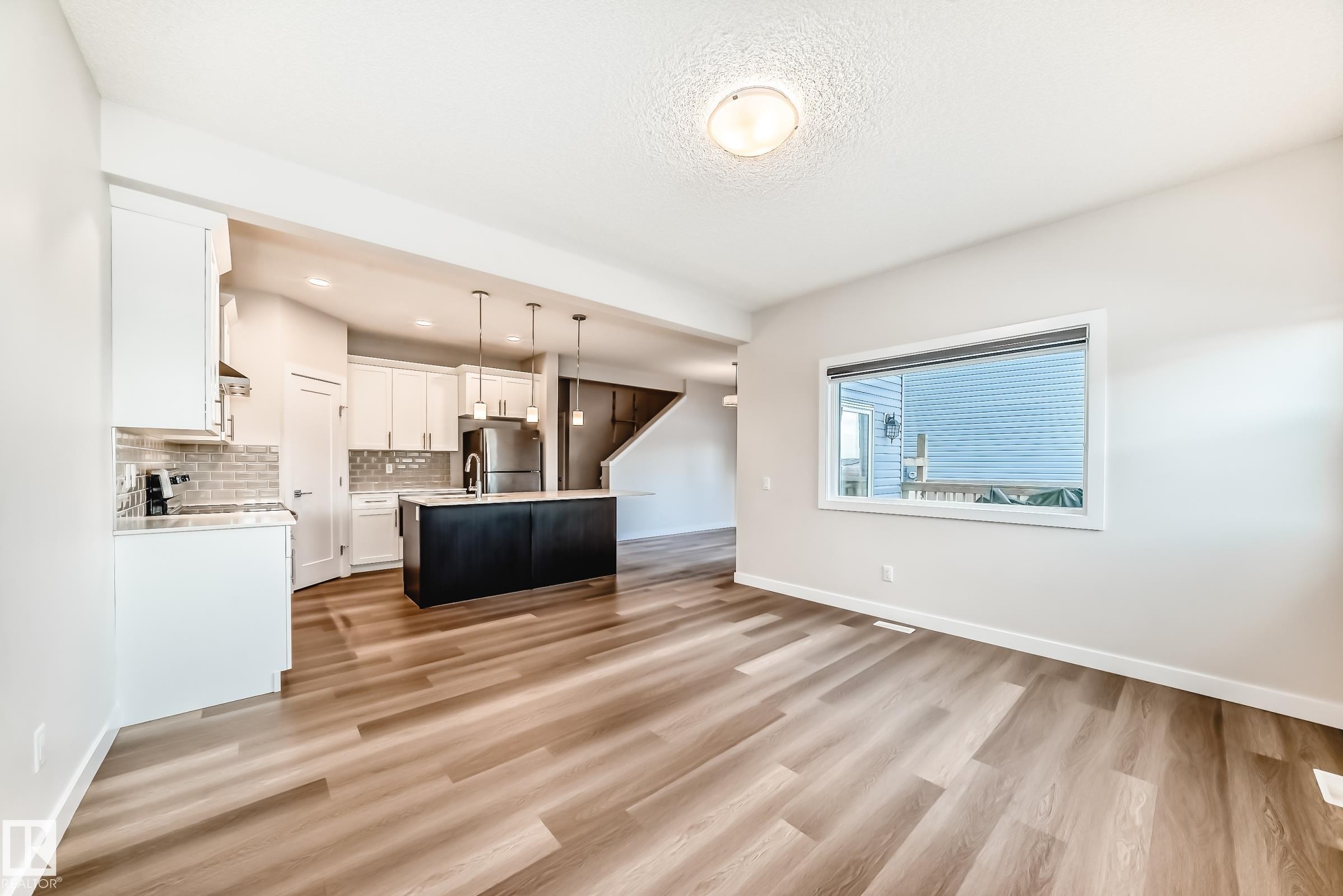 Unfurnished living room featuring light wood-type flooring and recessed lighting - 17926 62A Street, Edmonton, AB - Indoor Photo Showing Kitchen