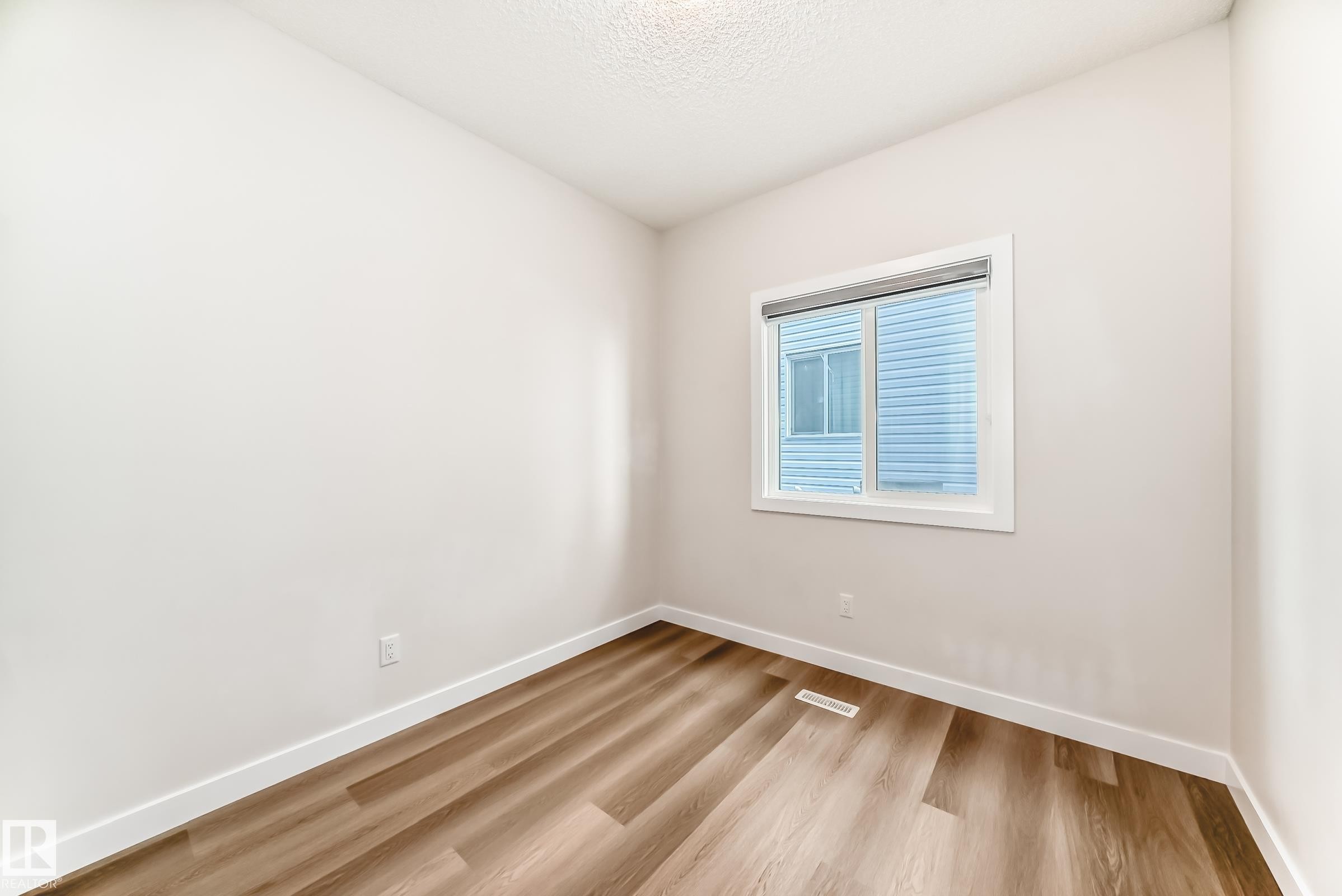 Empty room featuring light wood-type flooring and a textured ceiling - 17926 62A Street, Edmonton, AB - Indoor Photo Showing Other Room