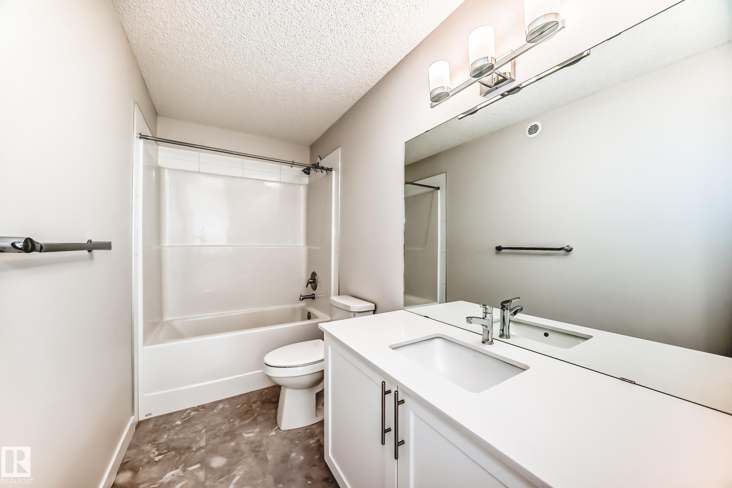 Bathroom with a textured ceiling, vanity, and shower combination - 17926 62A Street, Edmonton, AB - Indoor Photo Showing Bathroom