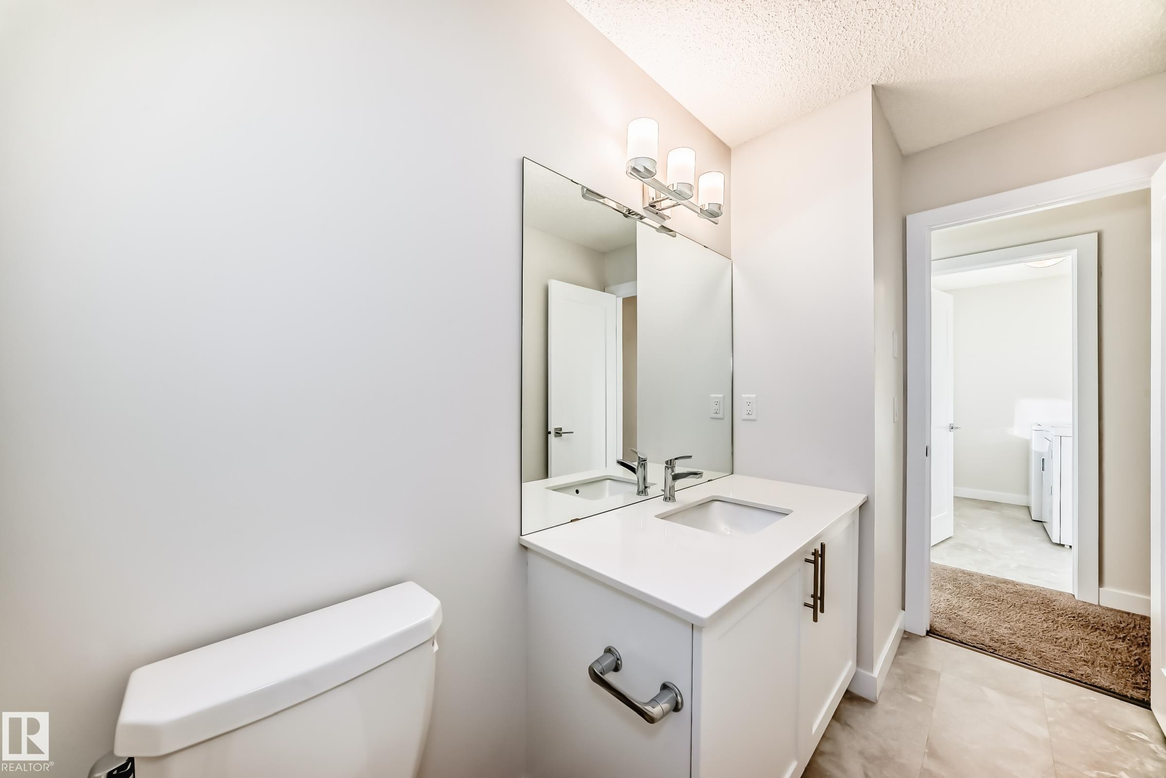 Half bathroom with vanity and a textured ceiling - 17926 62A Street, Edmonton, AB - Indoor Photo Showing Bathroom
