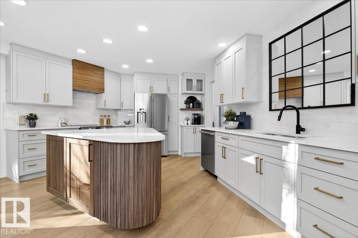 Kitchen featuring two tone cabinetry, recessed lighting, stainless steel appliances, open shelves, and light stone counters - 218 Omand Drive, Edmonton, AB - Indoor Photo Showing Kitchen With Upgraded Kitchen