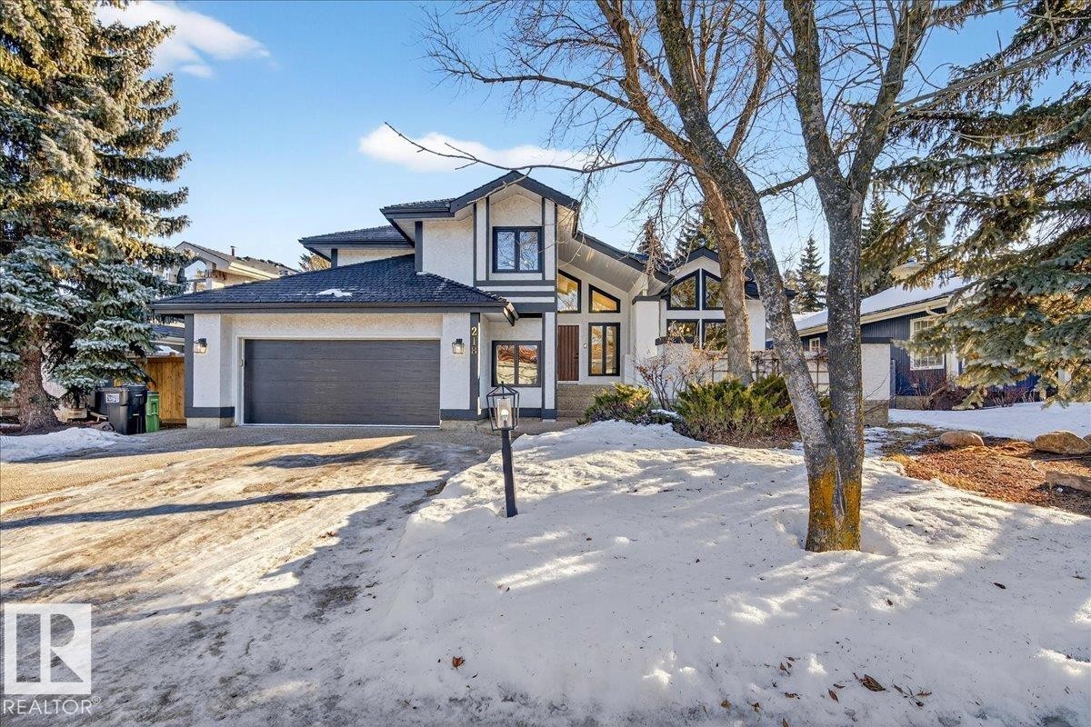 View of front of house with driveway, a garage, and stucco siding - 218 Omand Drive, Edmonton, AB - Outdoor With Facade