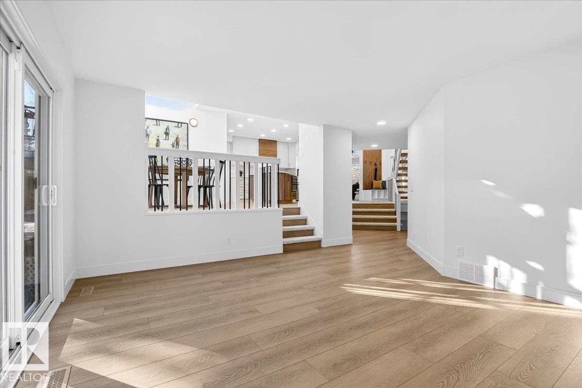 Unfurnished living room with stairway and light wood-style flooring - 218 Omand Drive, Edmonton, AB - Indoor