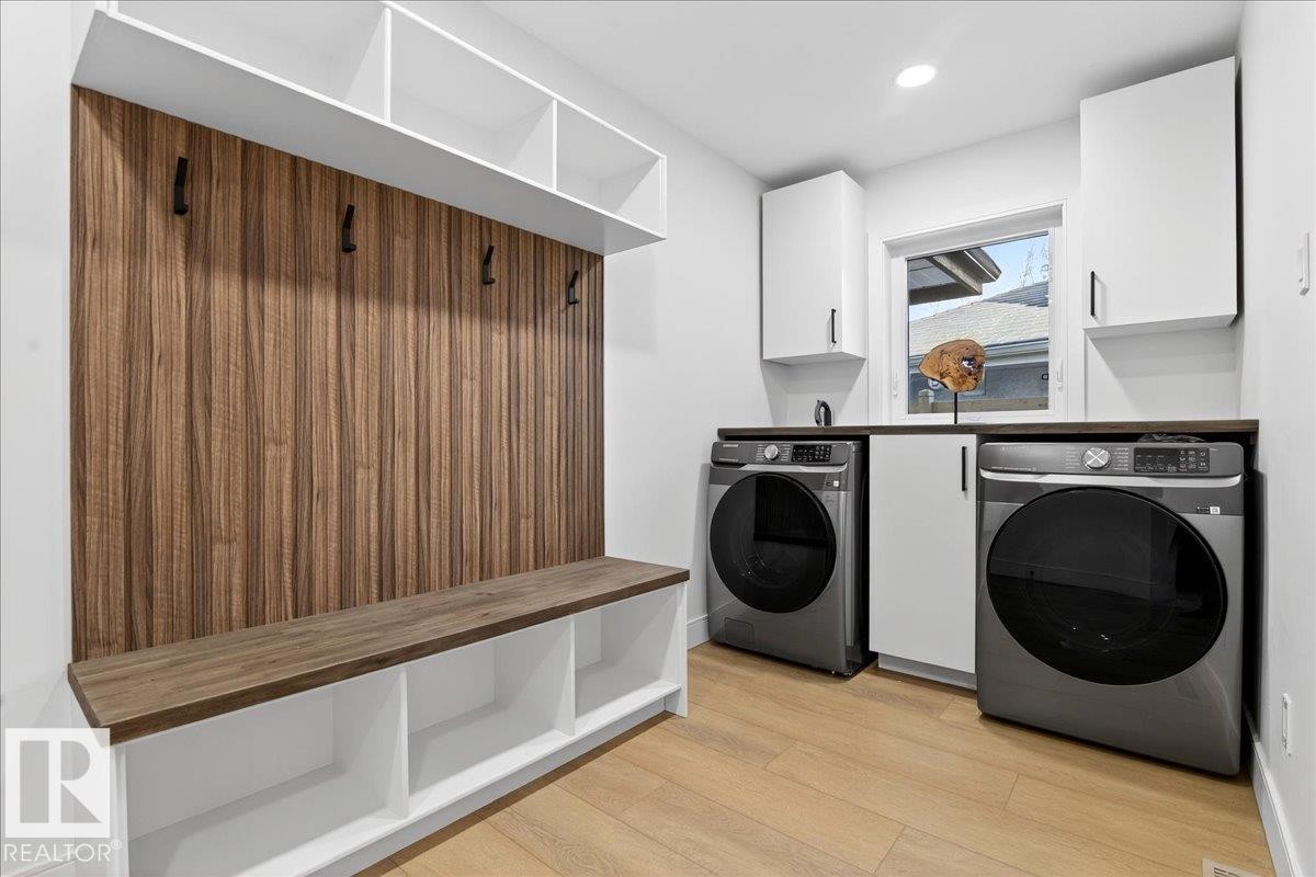 Laundry area featuring light wood-type flooring, washing machine and dryer, recessed lighting, and cabinet space - 218 Omand Drive, Edmonton, AB - Indoor Photo Showing Laundry Room