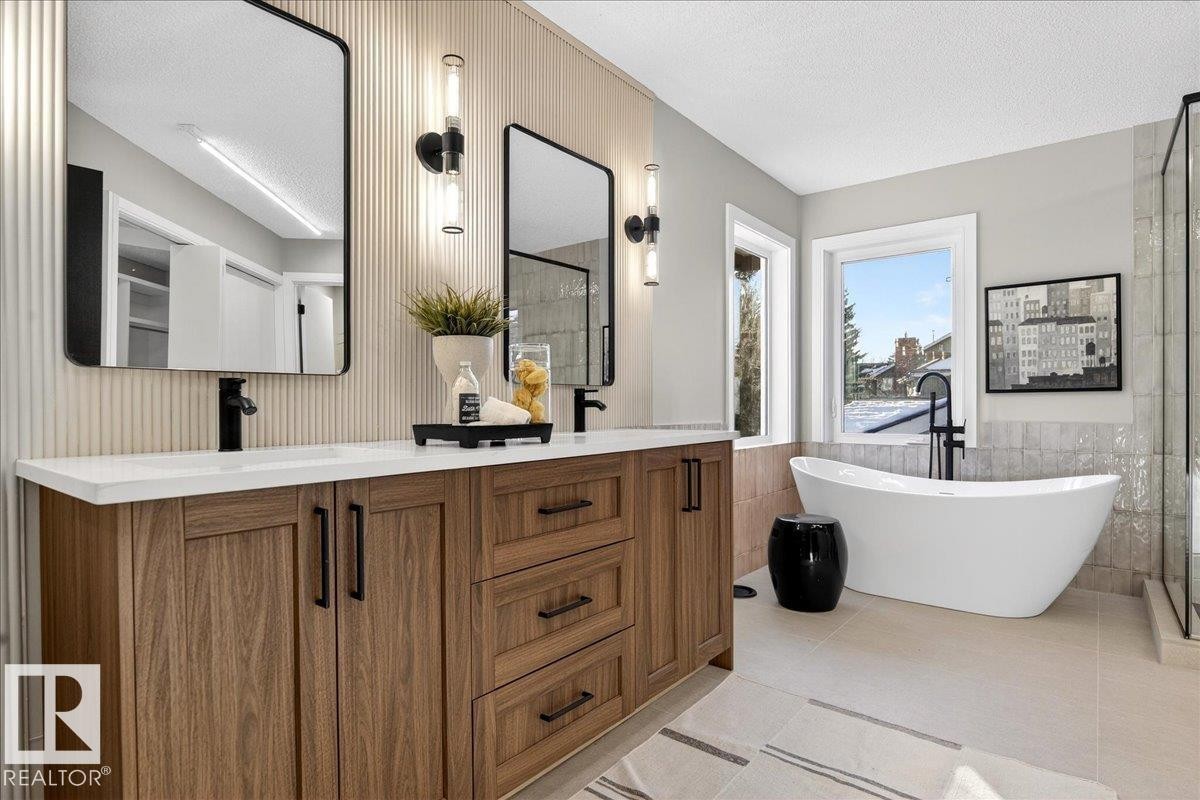 Bathroom featuring a stall shower, tile walls, vanity, a freestanding bath, and a textured ceiling - 218 Omand Drive, Edmonton, AB - Indoor Photo Showing Bathroom