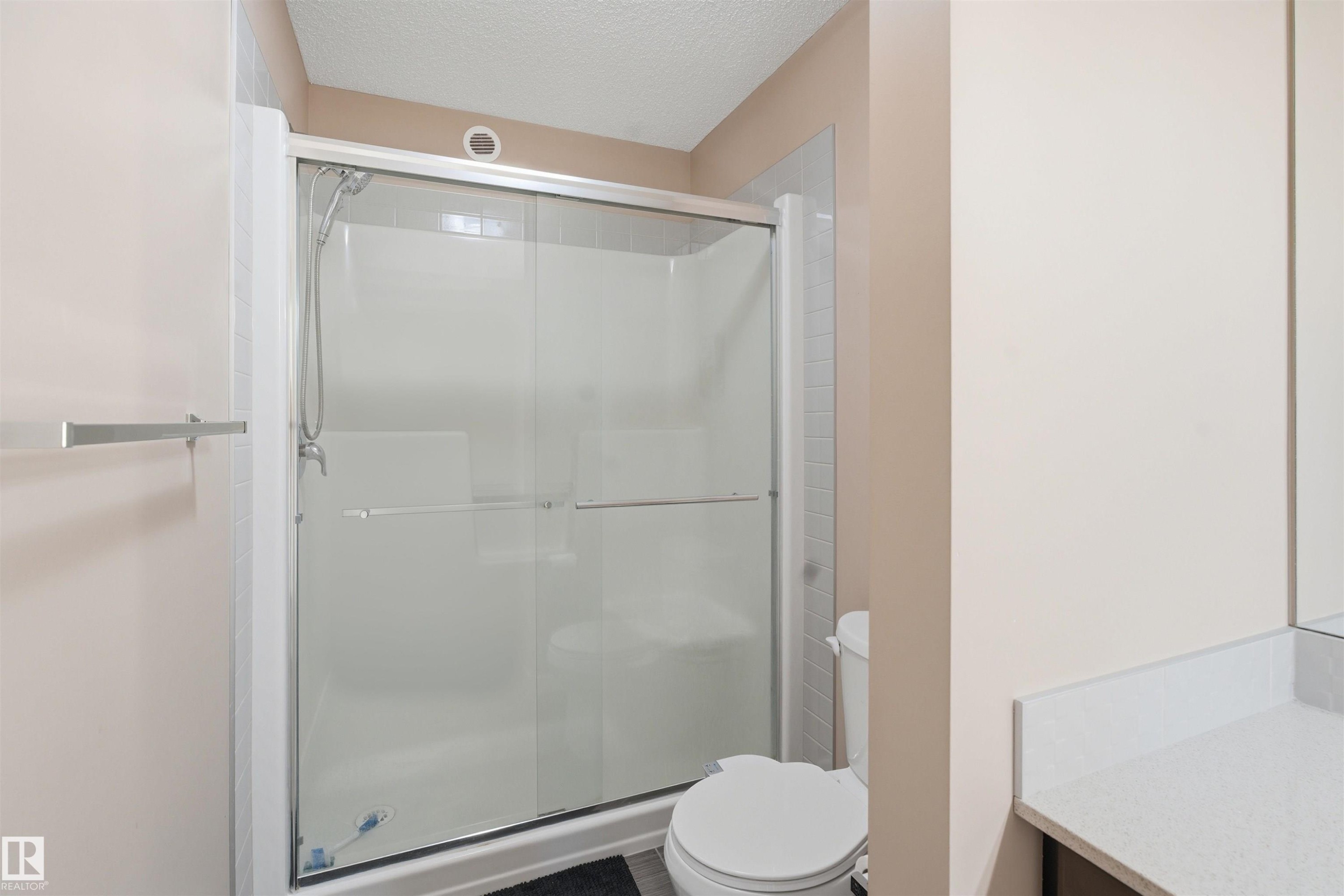 Bathroom with a textured ceiling, a shower stall, and vanity - 5003 Andison Close, Edmonton, AB - Indoor Photo Showing Bathroom