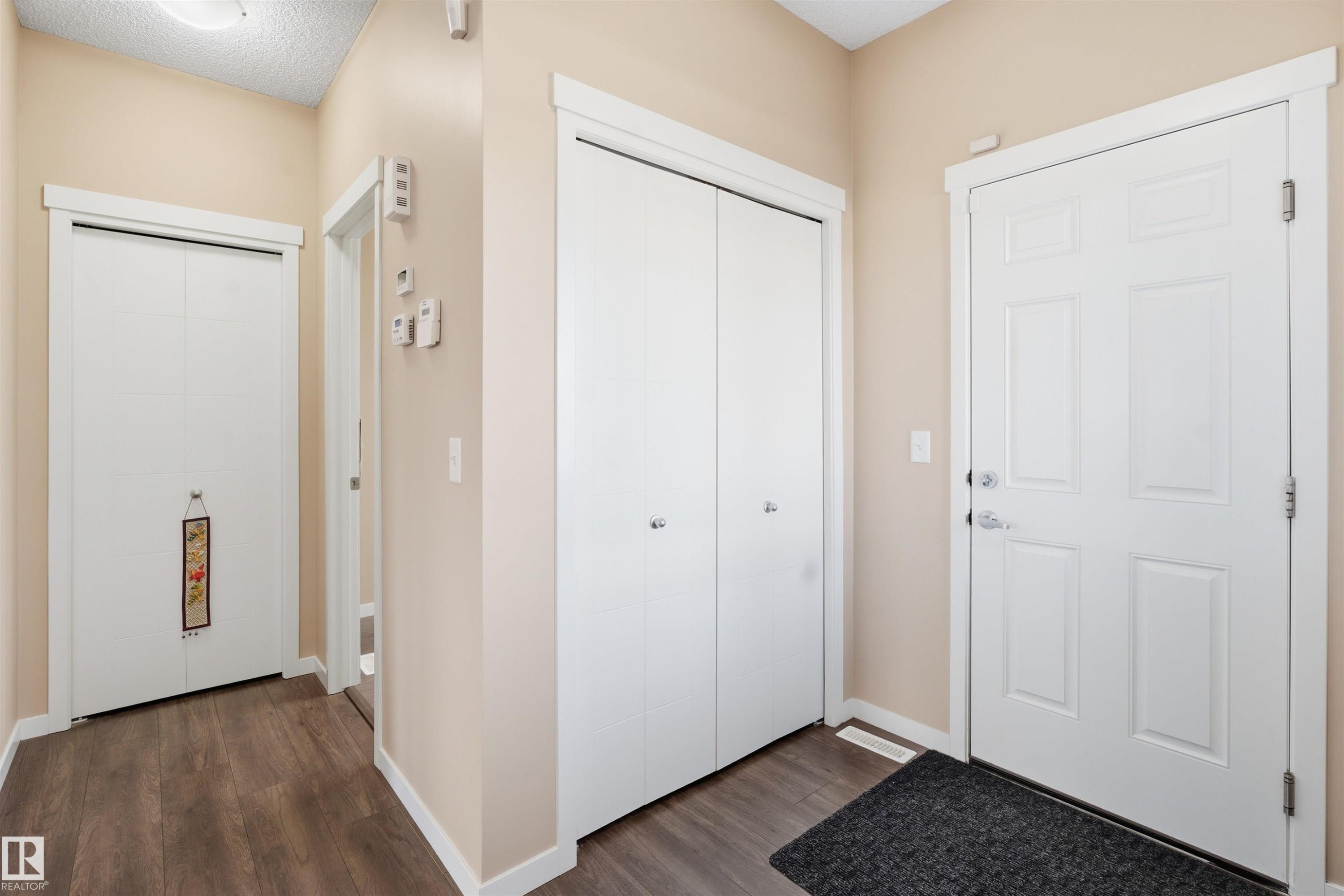 Entryway with dark wood-style floors and a textured ceiling - 5003 Andison Close, Edmonton, AB - Indoor Photo Showing Other Room