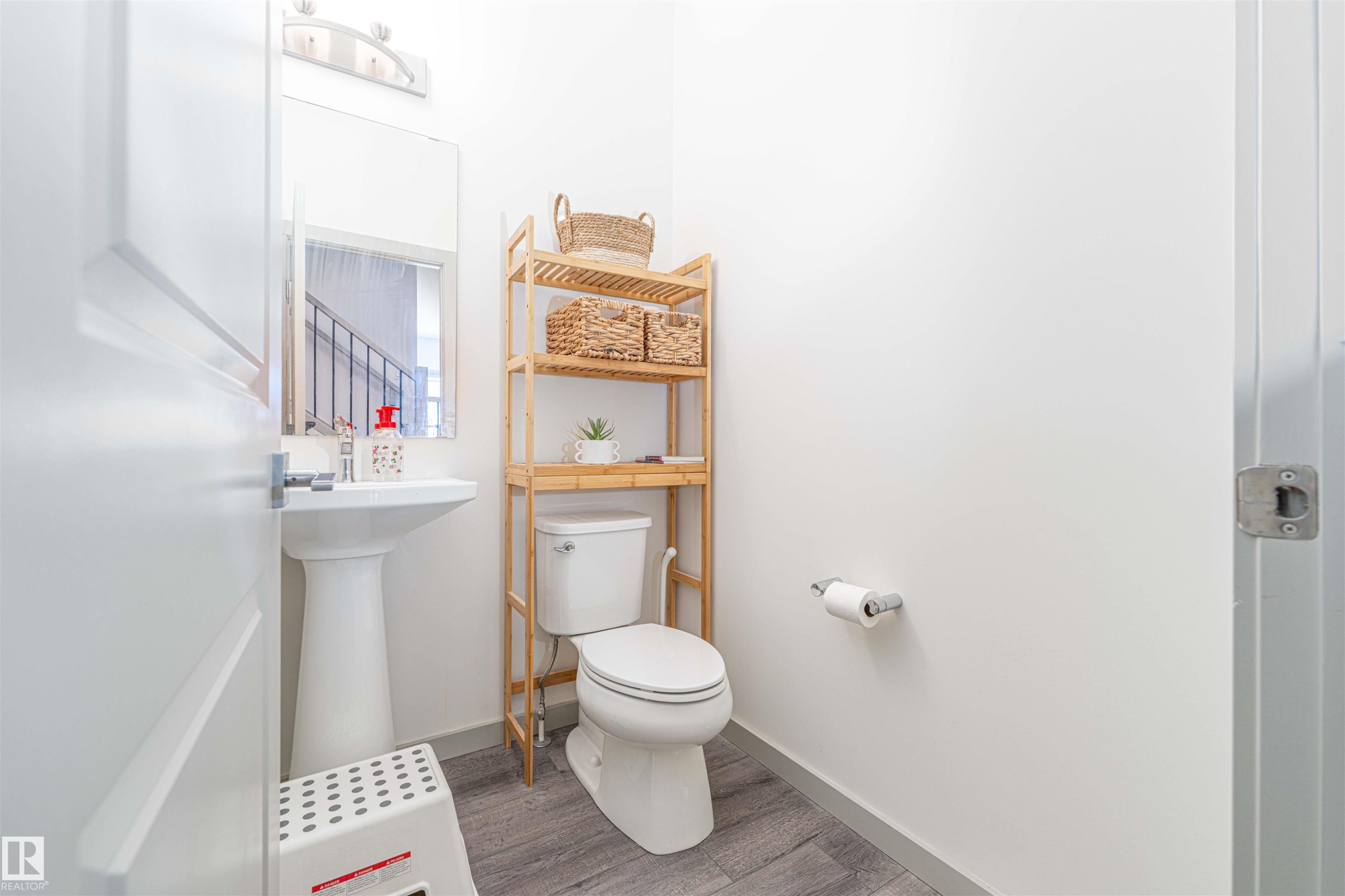 Half bath featuring toilet and wood finished floors - 2330 Kelly Circle, Edmonton, AB - Indoor Photo Showing Bathroom