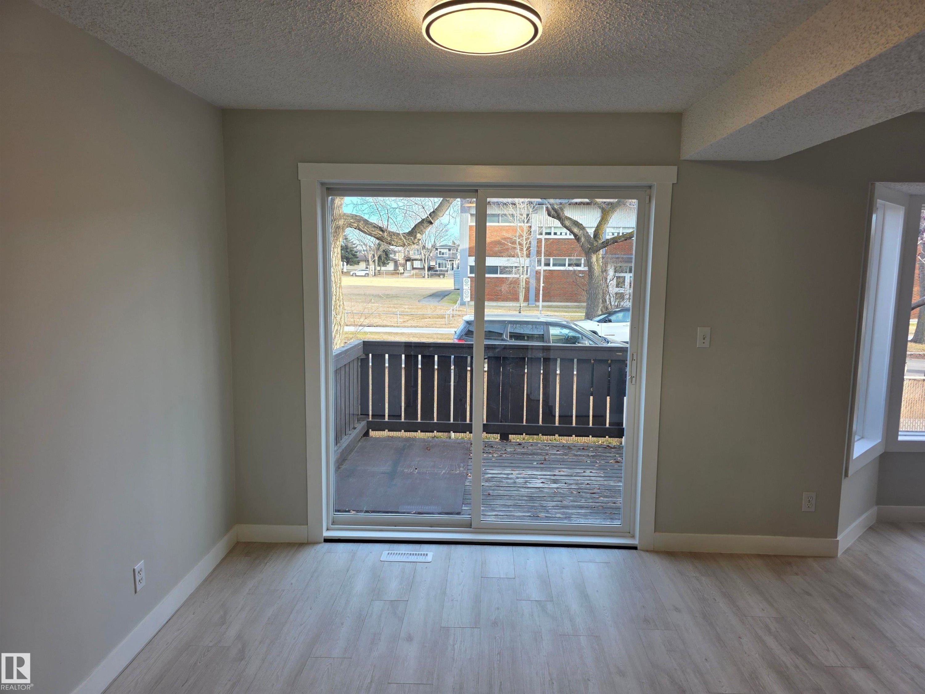 Doorway with wood finished floors and a textured ceiling - Edmonton, AB - Indoor Photo Showing Other Room