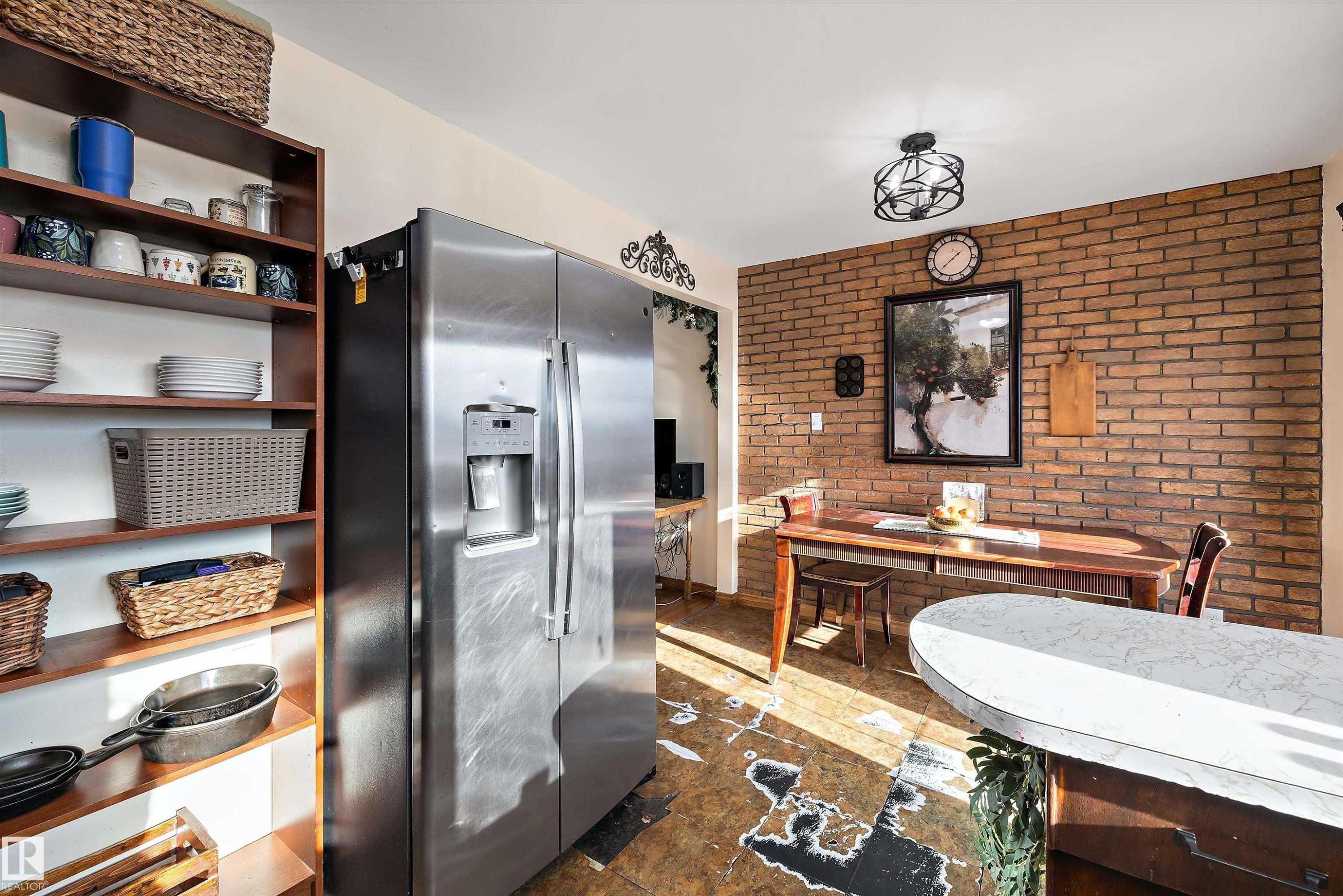 Kitchen with stainless steel refrigerator with ice dispenser and brick wall - 5703 143 Avenue, Edmonton, AB - Indoor