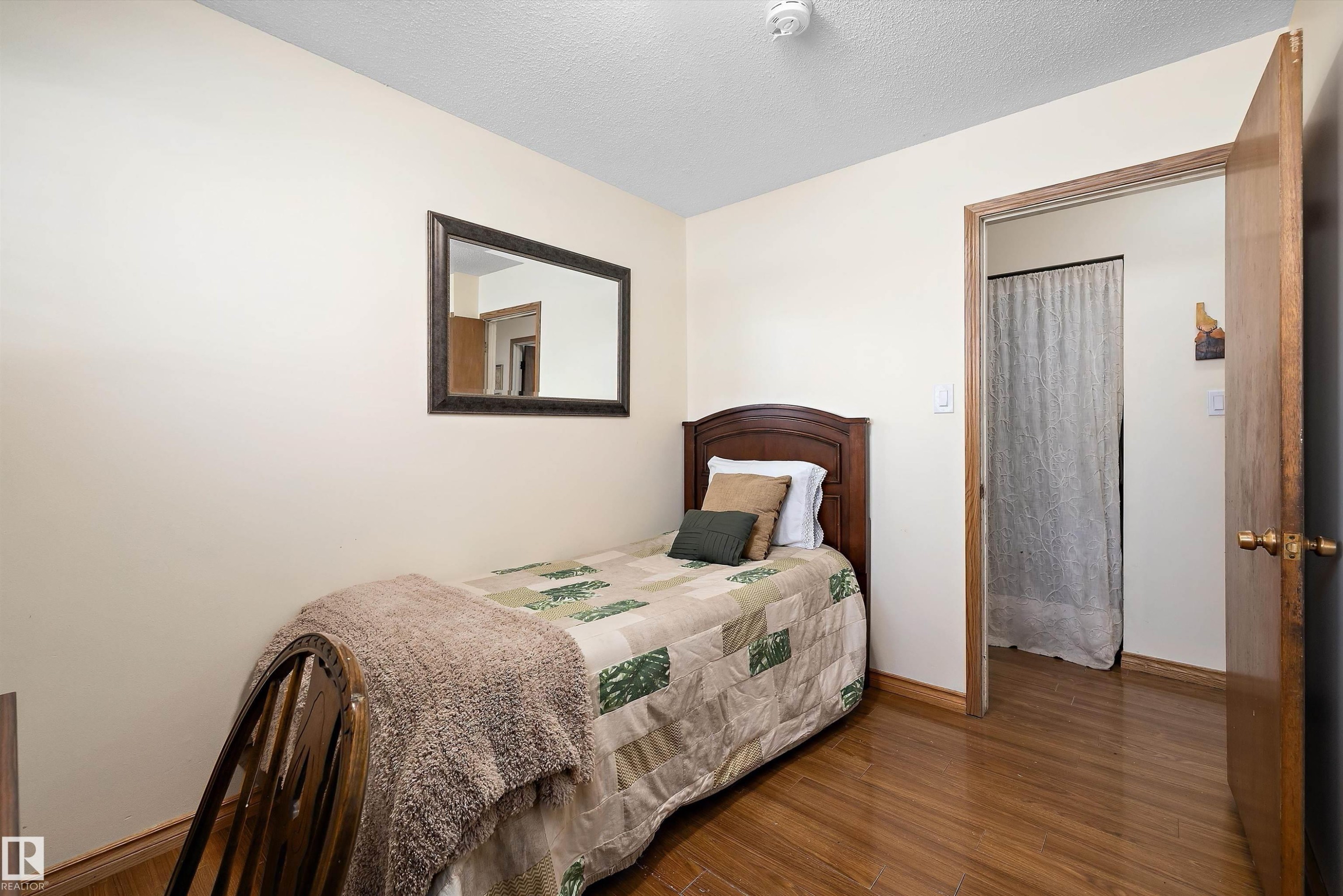 Bedroom featuring wood finished floors and a textured ceiling - 5703 143 Avenue, Edmonton, AB - Indoor Photo Showing Bedroom