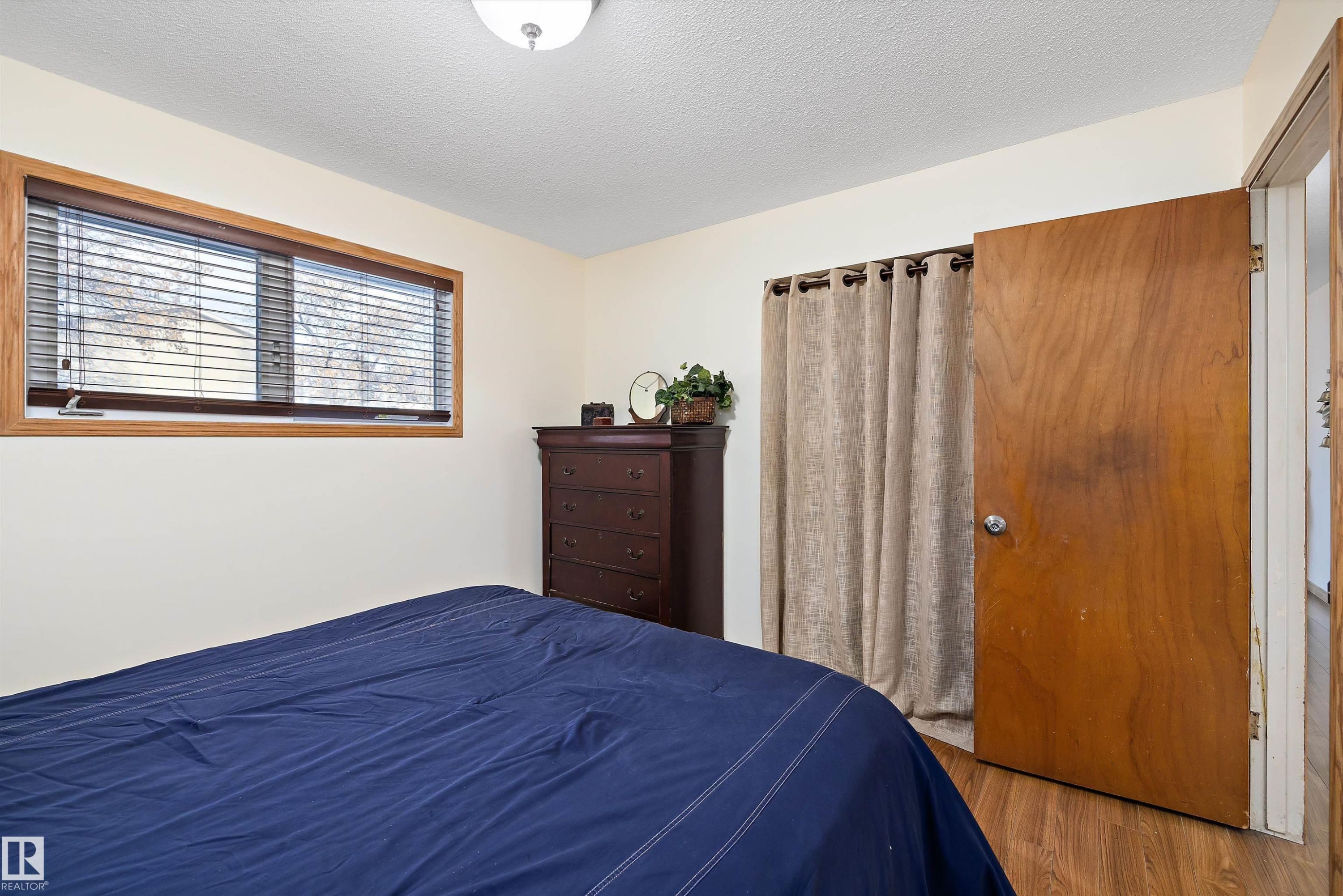 Bedroom featuring a textured ceiling and wood finished floors - 5703 143 Avenue, Edmonton, AB - Indoor Photo Showing Bedroom