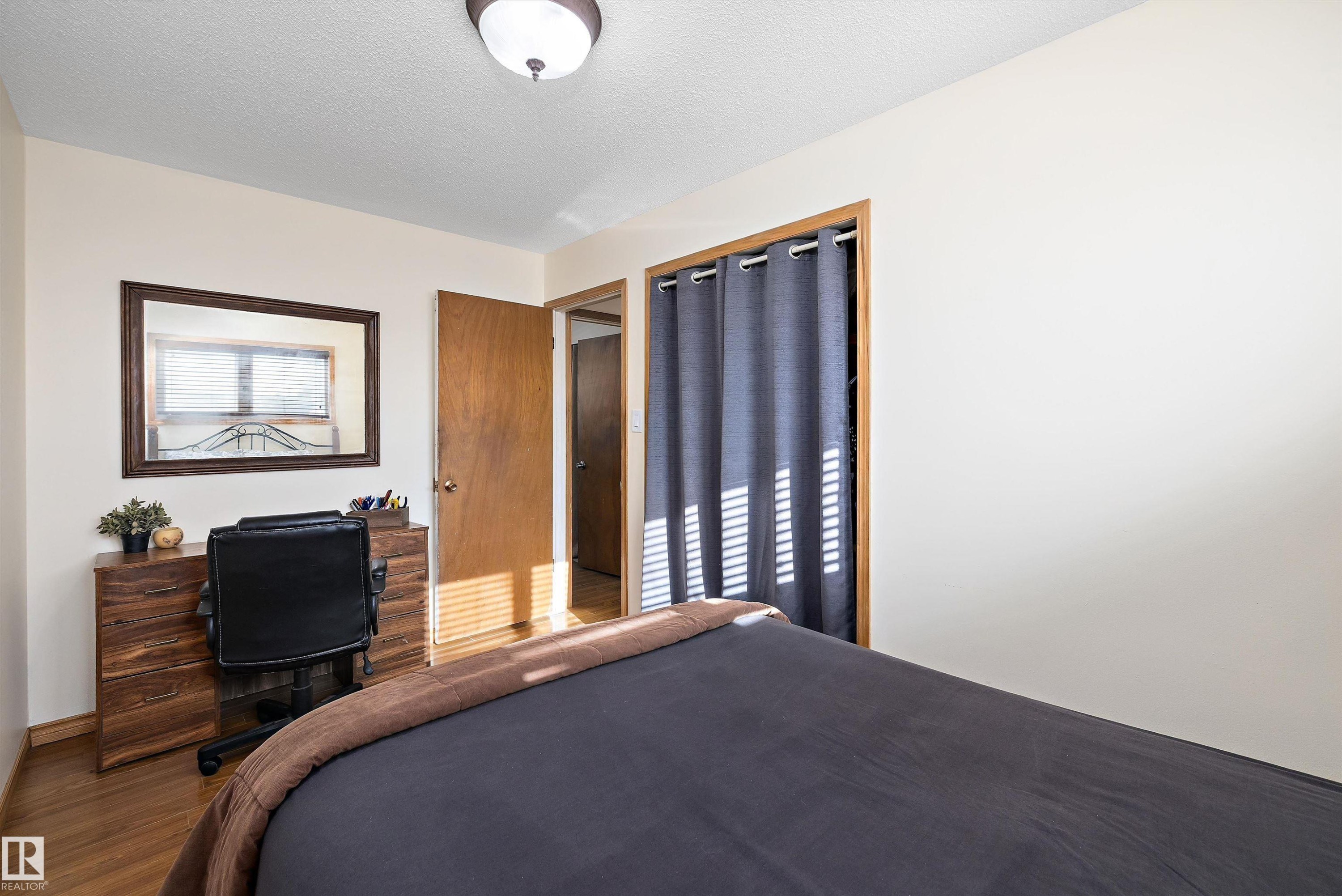 Bedroom featuring a textured ceiling and wood finished floors - 5703 143 Avenue, Edmonton, AB - Indoor Photo Showing Bedroom