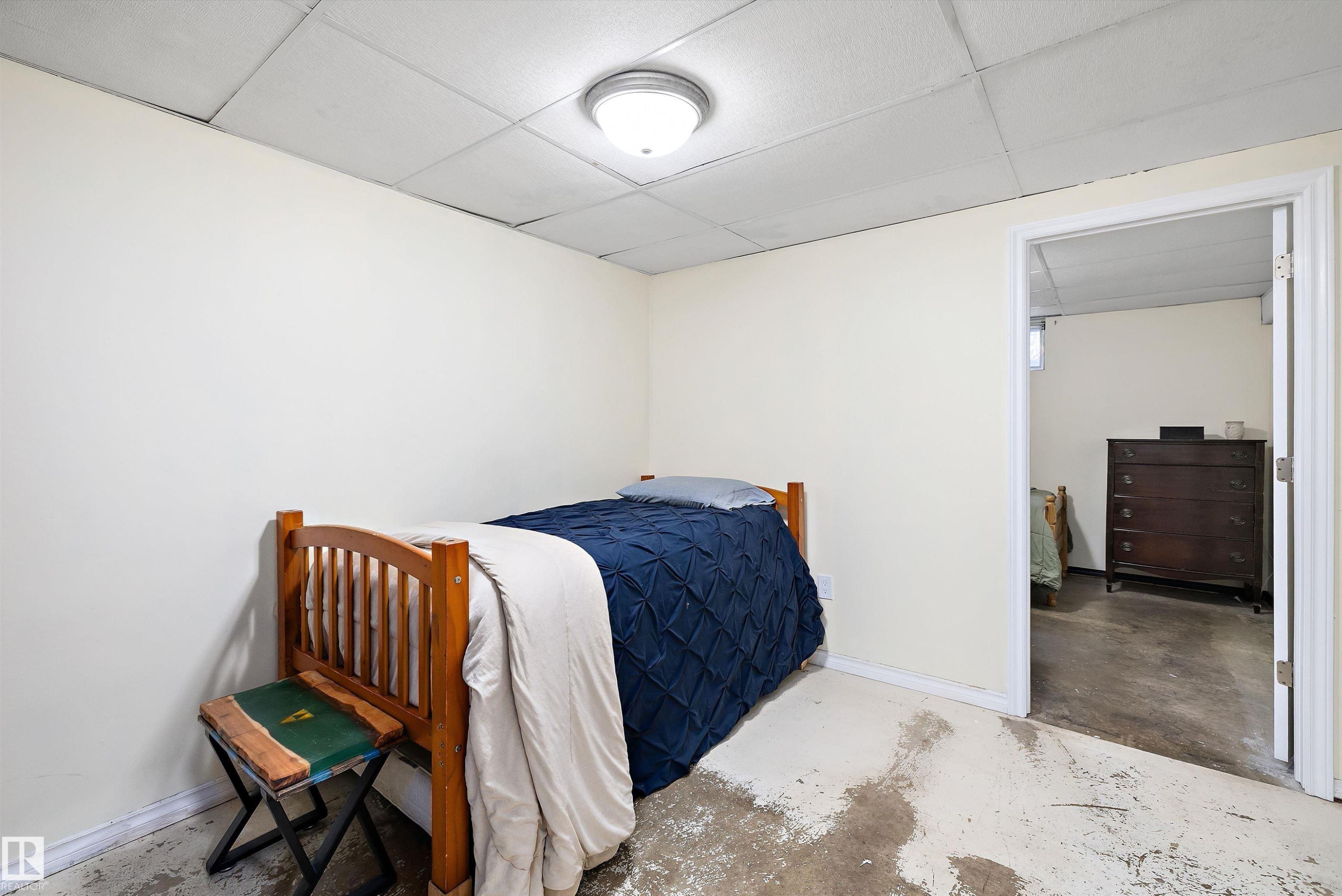 Bedroom featuring a paneled ceiling and concrete flooring - 5703 143 Avenue, Edmonton, AB - Indoor