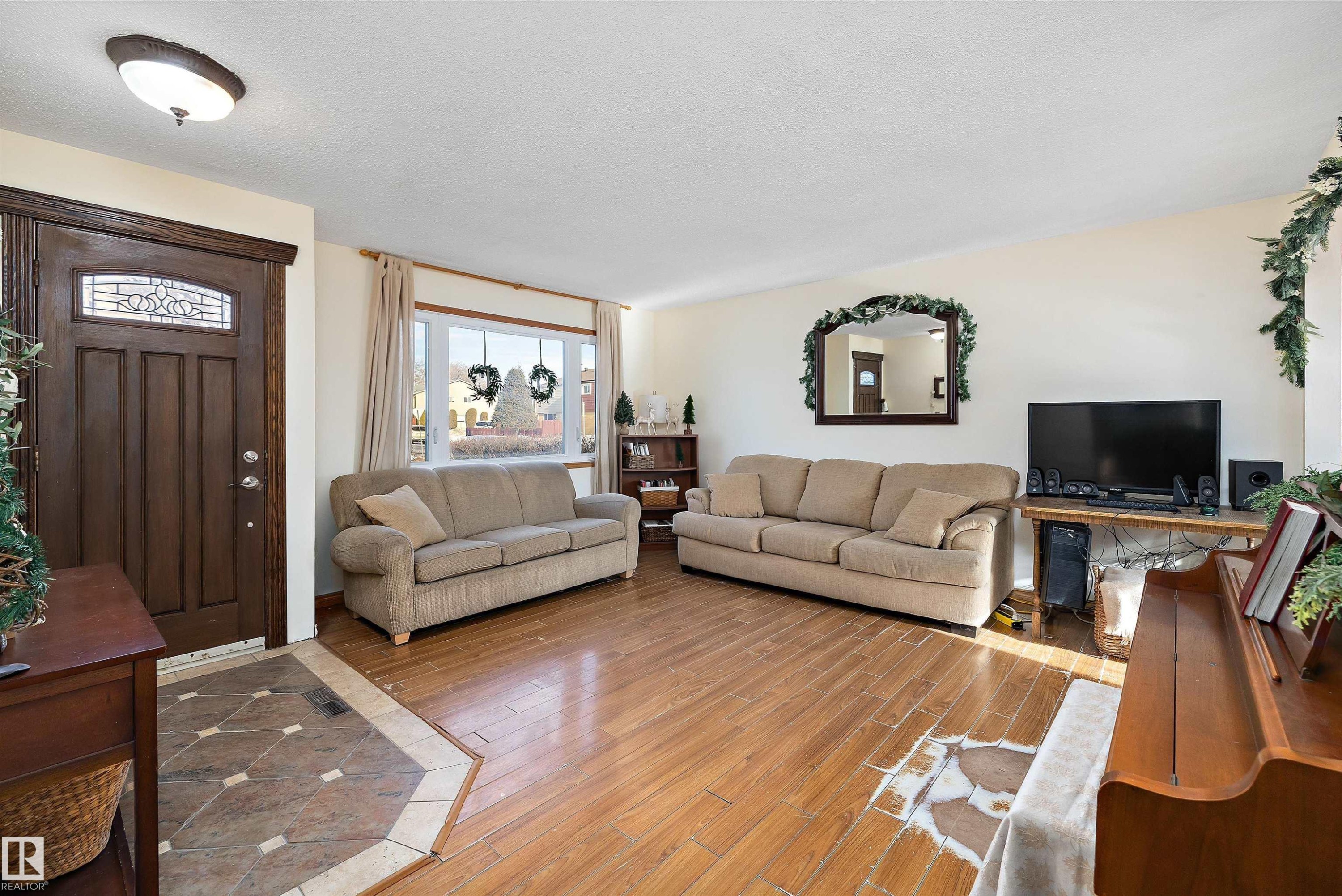 Living room with hardwood / wood-style flooring and a textured ceiling - 5703 143 Avenue, Edmonton, AB - Indoor Photo Showing Living Room
