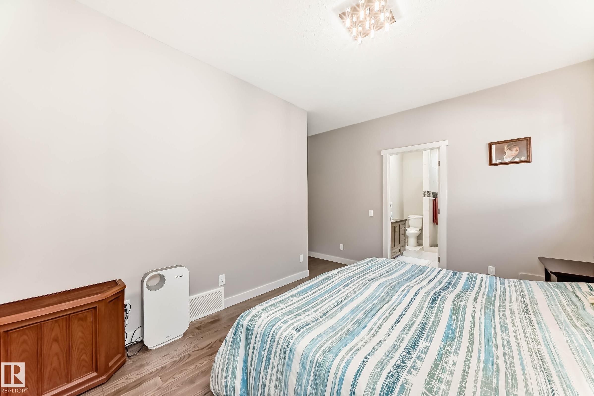 Bedroom with wood finished floors and ensuite bath - 7719 Getty Wynd, Edmonton, AB - Indoor Photo Showing Bedroom