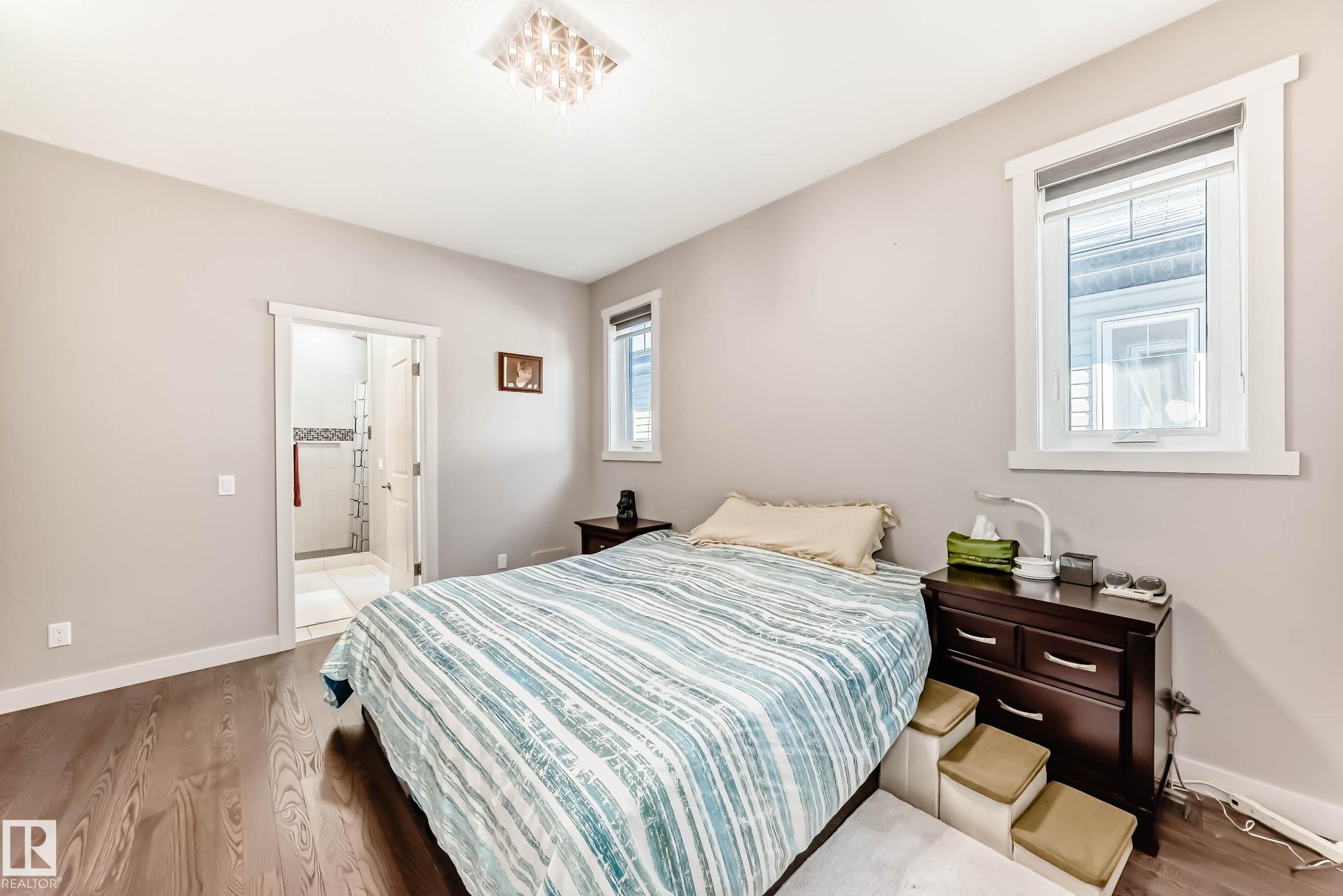 Bedroom featuring wood finished floors and connected bathroom - 7719 Getty Wynd, Edmonton, AB - Indoor Photo Showing Bedroom