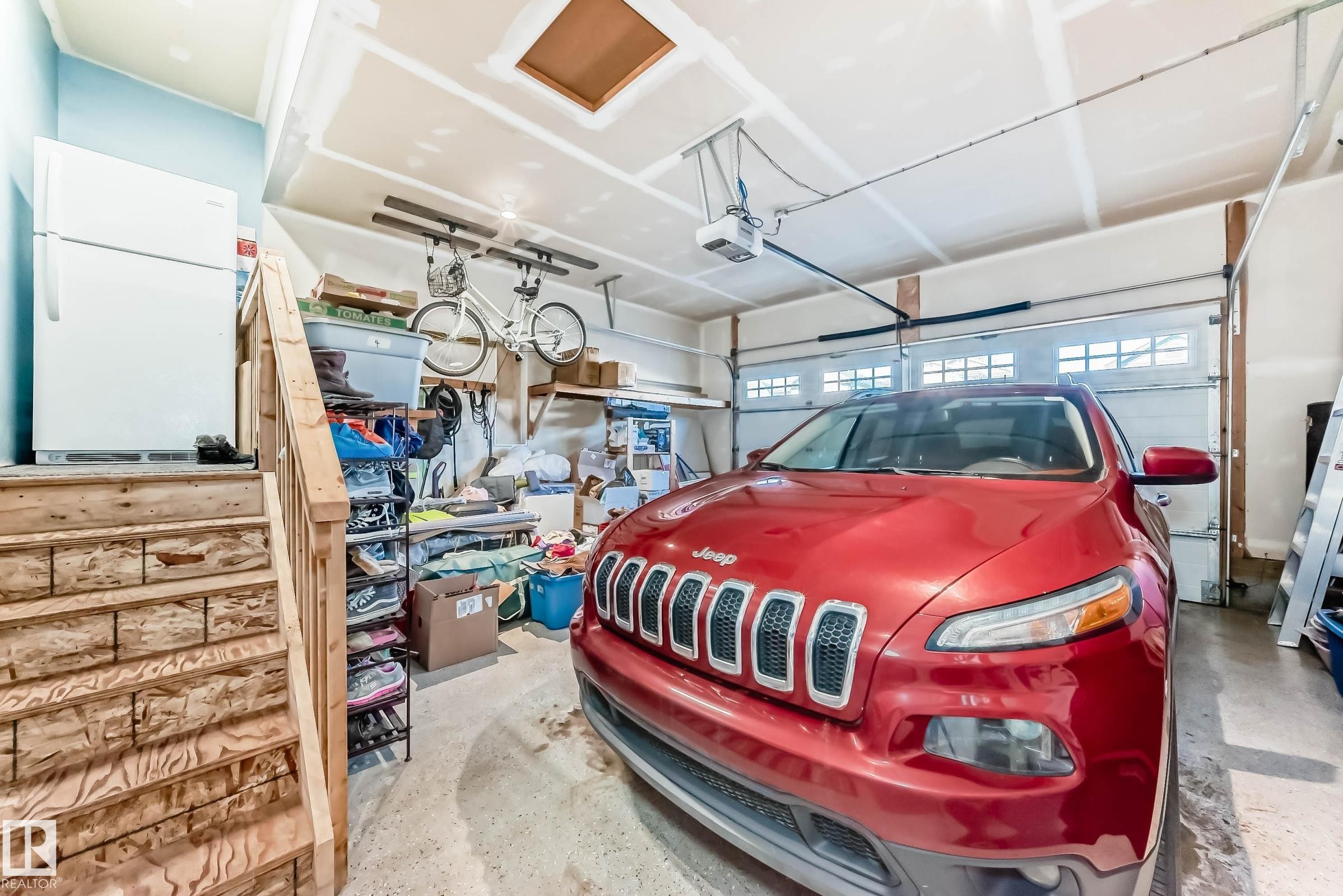 Garage featuring freestanding refrigerator and a garage door opener - 7719 Getty Wynd, Edmonton, AB - Indoor Photo Showing Garage
