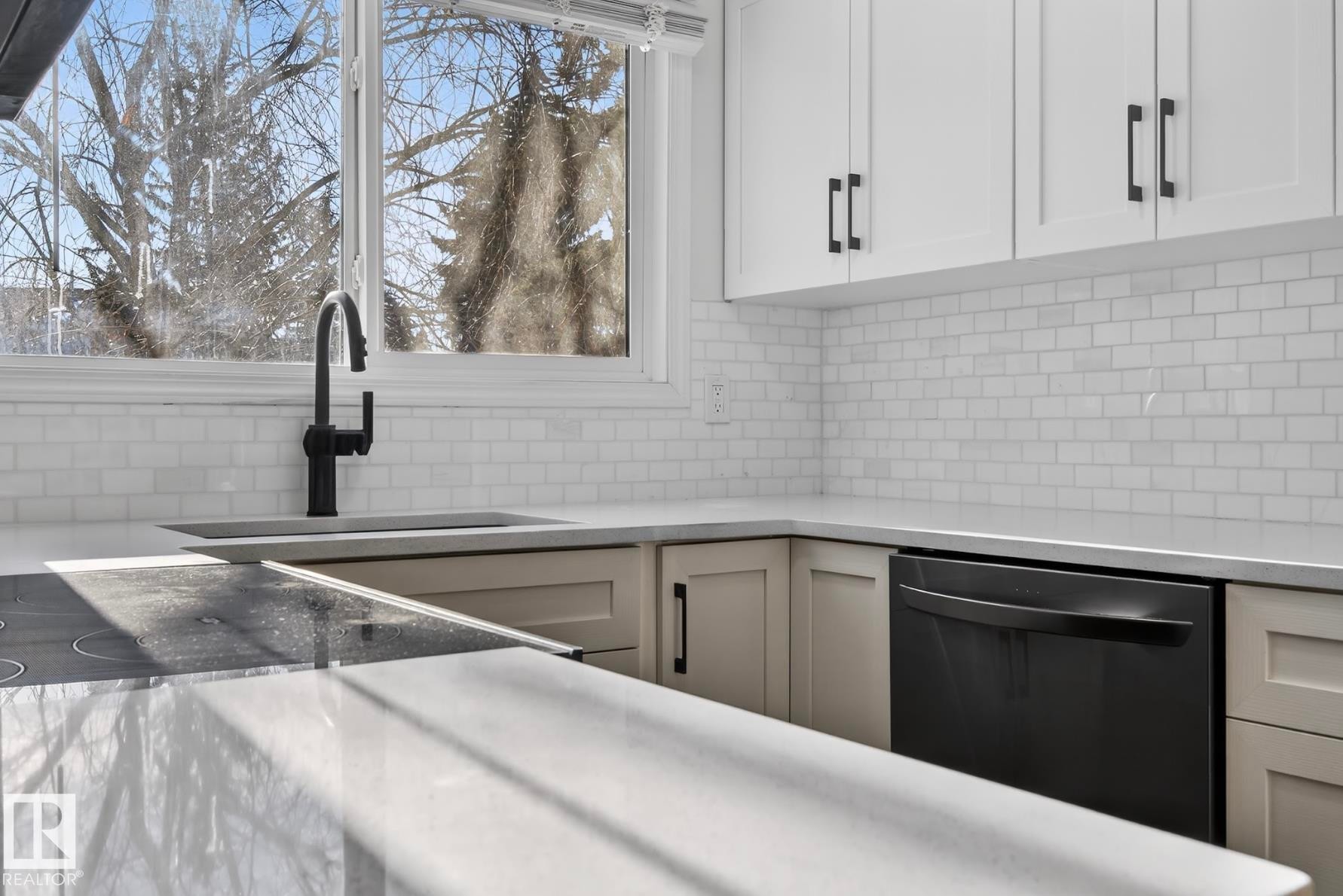 Kitchen featuring dishwasher, light stone counters, white cabinets, and decorative backsplash - 9969 171 Ave, Edmonton, AB - Indoor Photo Showing Kitchen