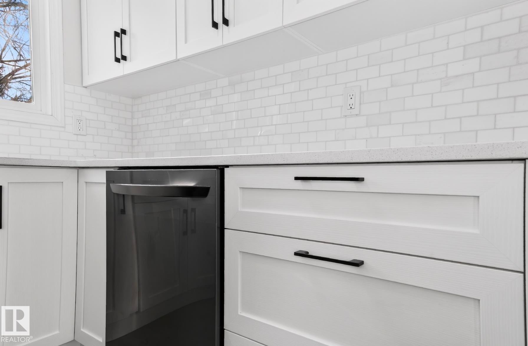 Kitchen view of light stone countertops, white cabinets, and stainless steel dishwasher - 9969 171 Ave, Edmonton, AB - Indoor
