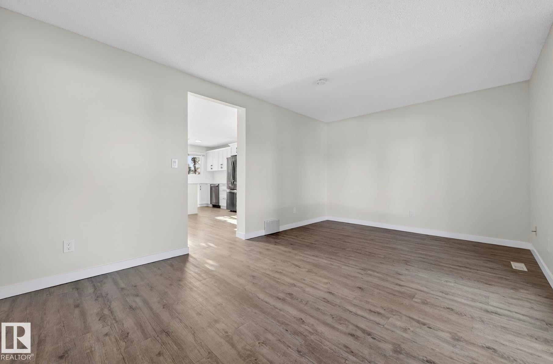 Empty room featuring dark wood finished floors - 9969 171 Ave, Edmonton, AB - Indoor Photo Showing Other Room