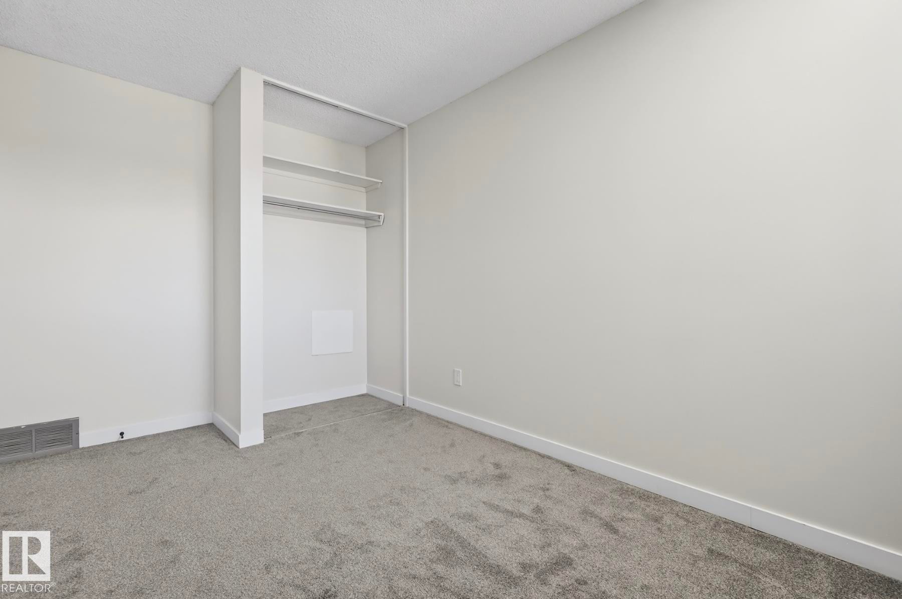 Unfurnished bedroom with light colored carpet and a textured ceiling - 9969 171 Ave, Edmonton, AB - Indoor Photo Showing Other Room