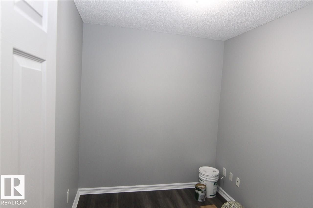 Spare room featuring dark wood-style floors and a textured ceiling - 404 4407 23 Street, Edmonton, AB - Indoor Photo Showing Other Room