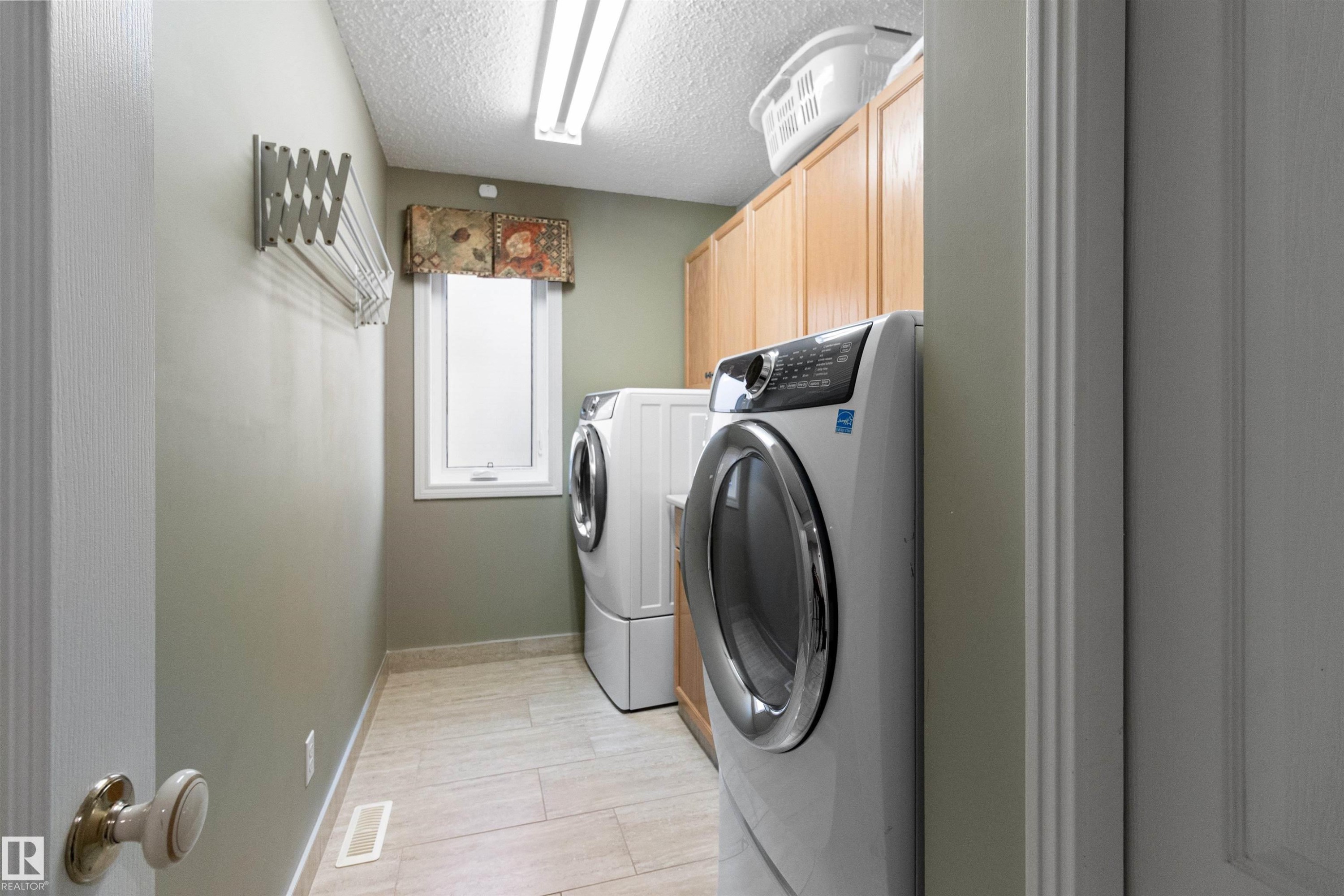 Laundry area featuring cabinet space, washer and clothes dryer, and a textured ceiling - 519 Buchanan Road, Edmonton, AB - Indoor Photo Showing Laundry Room