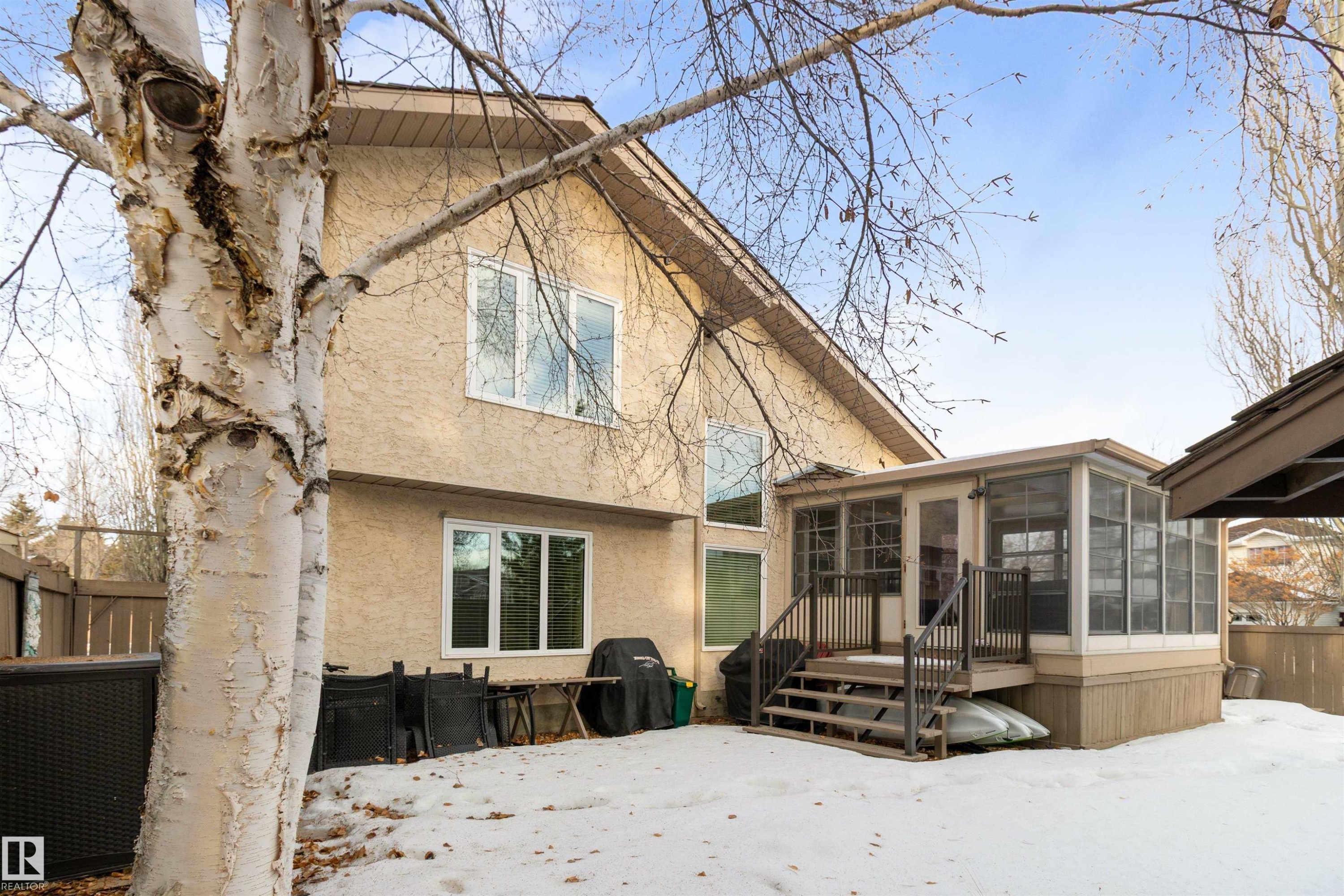 Snow covered property featuring a sunroom and stucco siding - 519 Buchanan Road, Edmonton, AB - Outdoor With Deck Patio Veranda