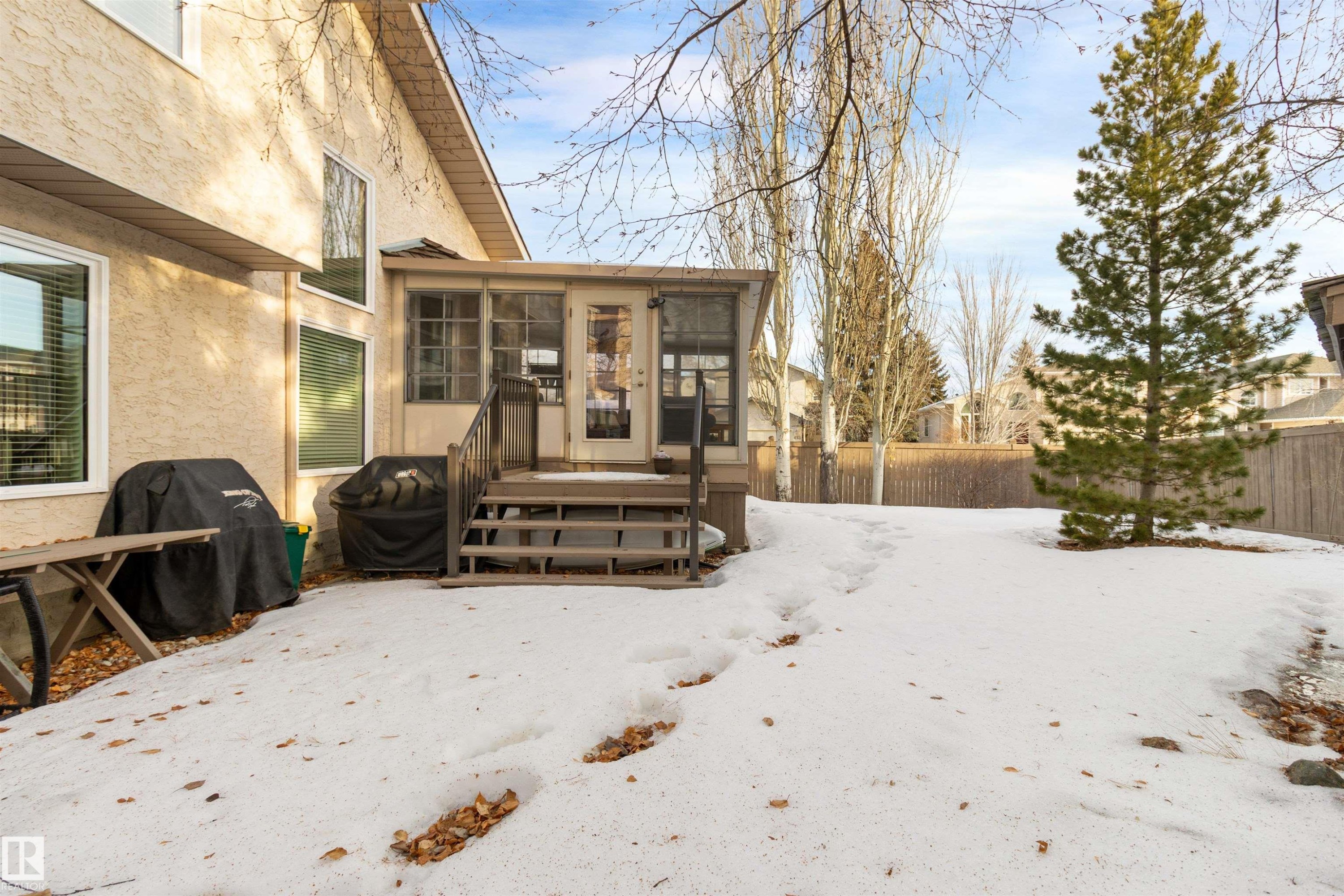Snow covered property featuring a sunroom and stucco siding - 519 Buchanan Road, Edmonton, AB - Outdoor With Deck Patio Veranda
