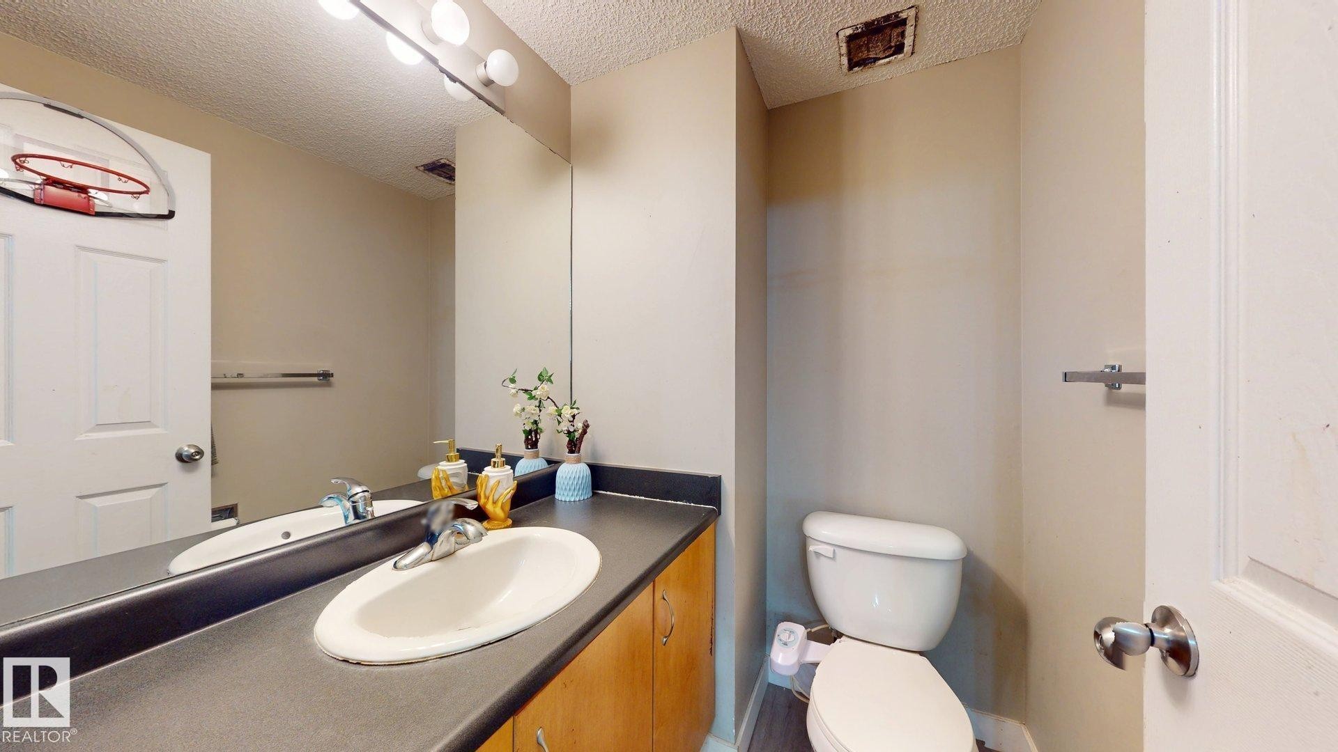Half bath featuring vanity and a textured ceiling - 1150 37B Avenue, Edmonton, AB - Indoor Photo Showing Bathroom