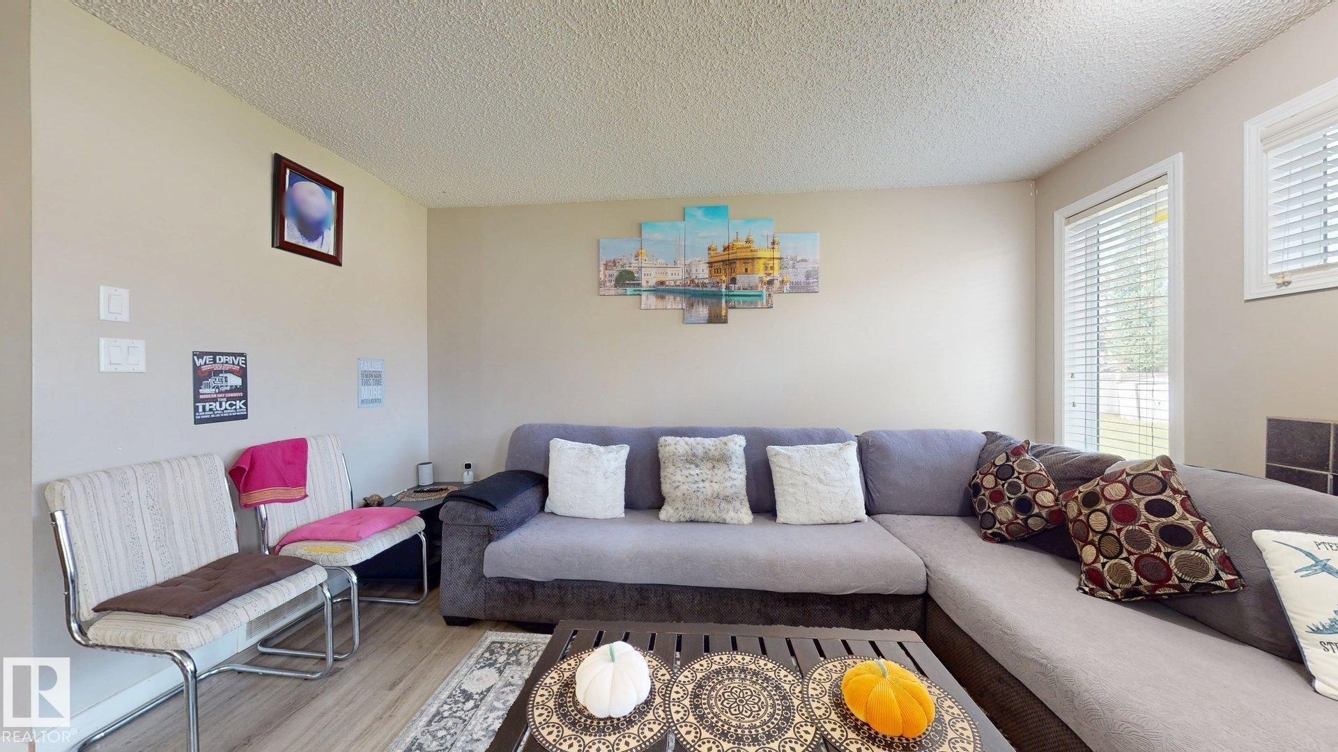 Living area featuring wood finished floors and a textured ceiling - 1150 37B Avenue, Edmonton, AB - Indoor Photo Showing Living Room