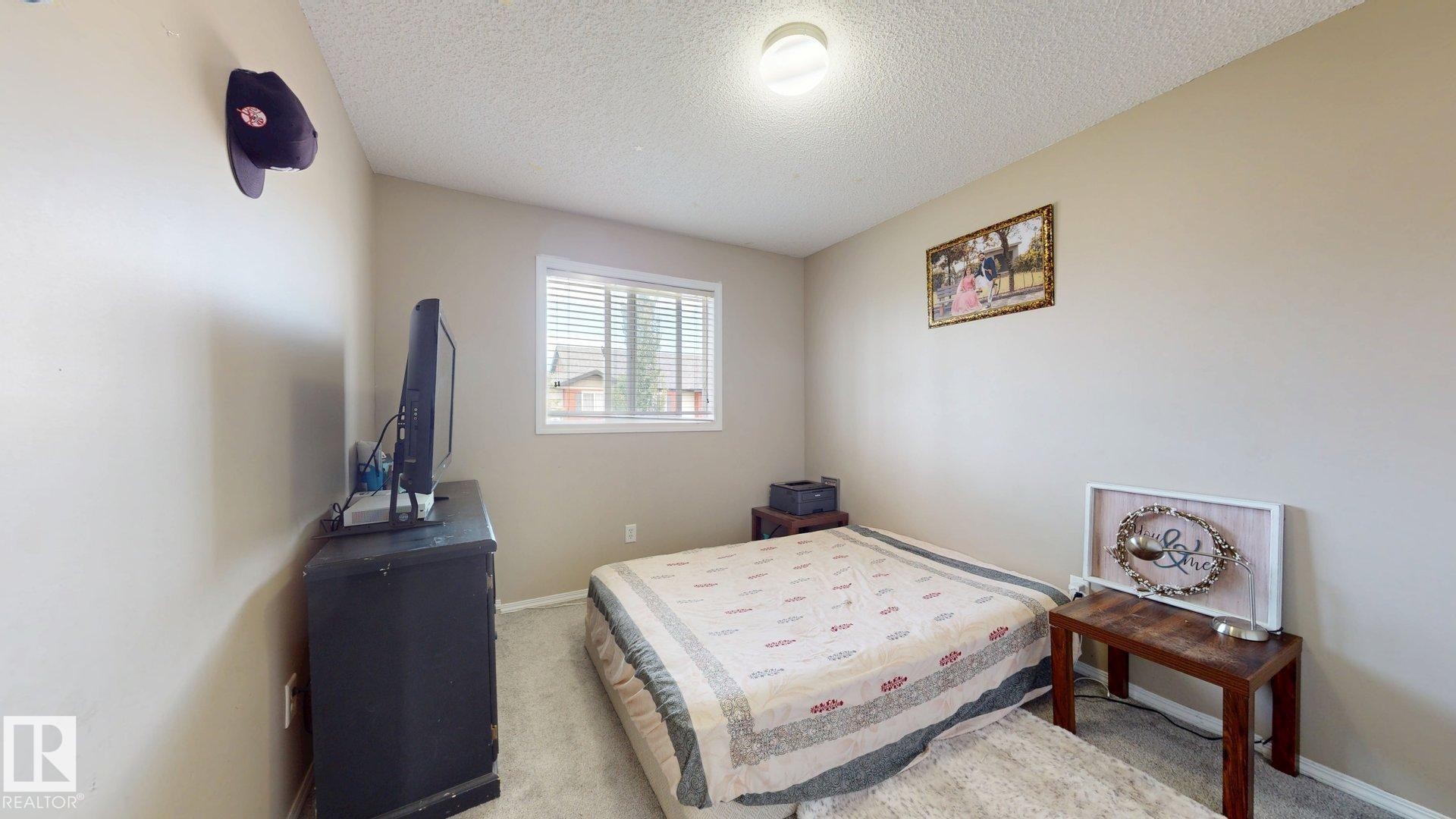 Bedroom with light colored carpet and a textured ceiling - 1150 37B Avenue, Edmonton, AB - Indoor Photo Showing Bedroom