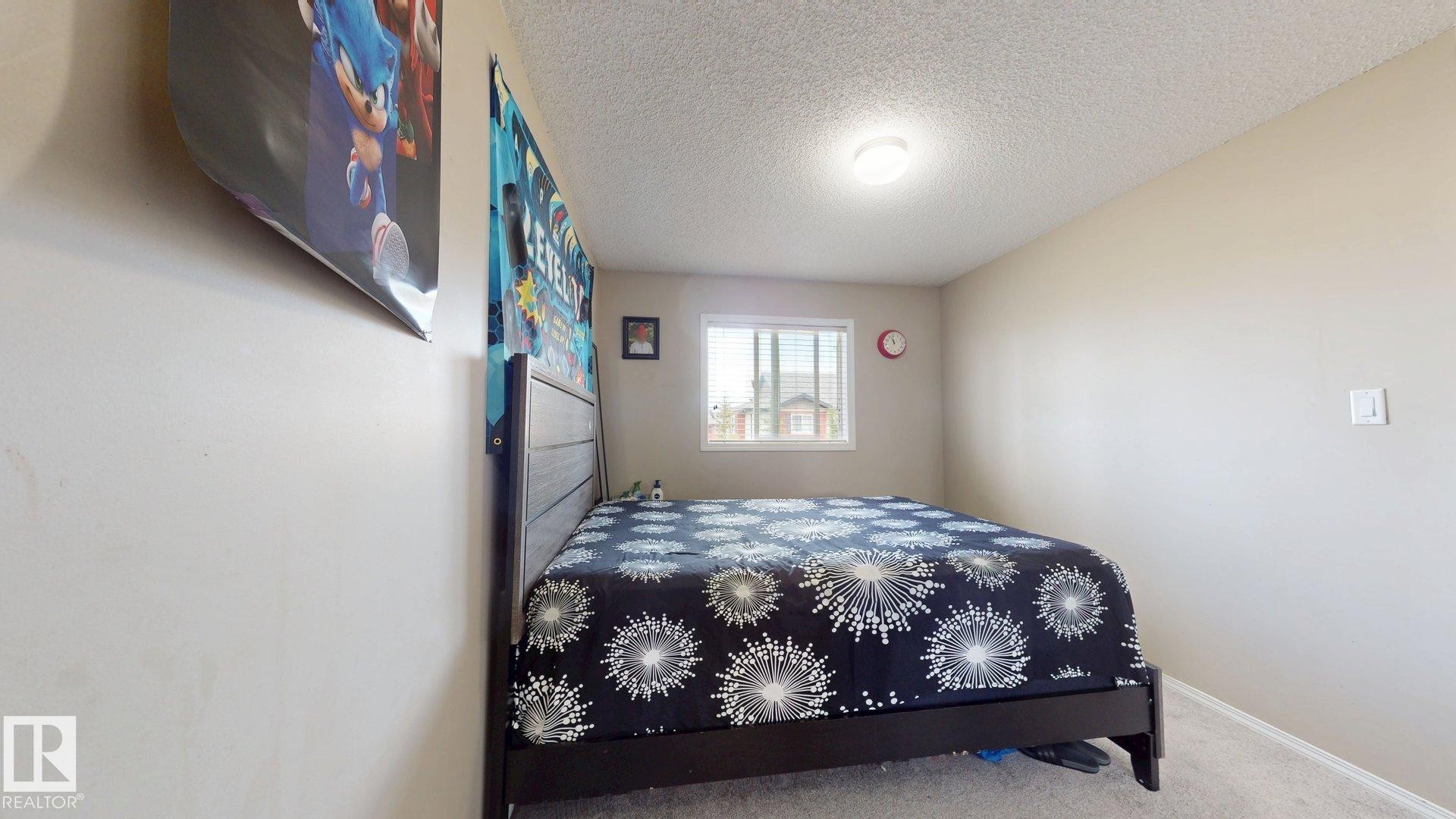 Bedroom featuring a textured ceiling and carpet floors - 1150 37B Avenue, Edmonton, AB - Indoor Photo Showing Bedroom