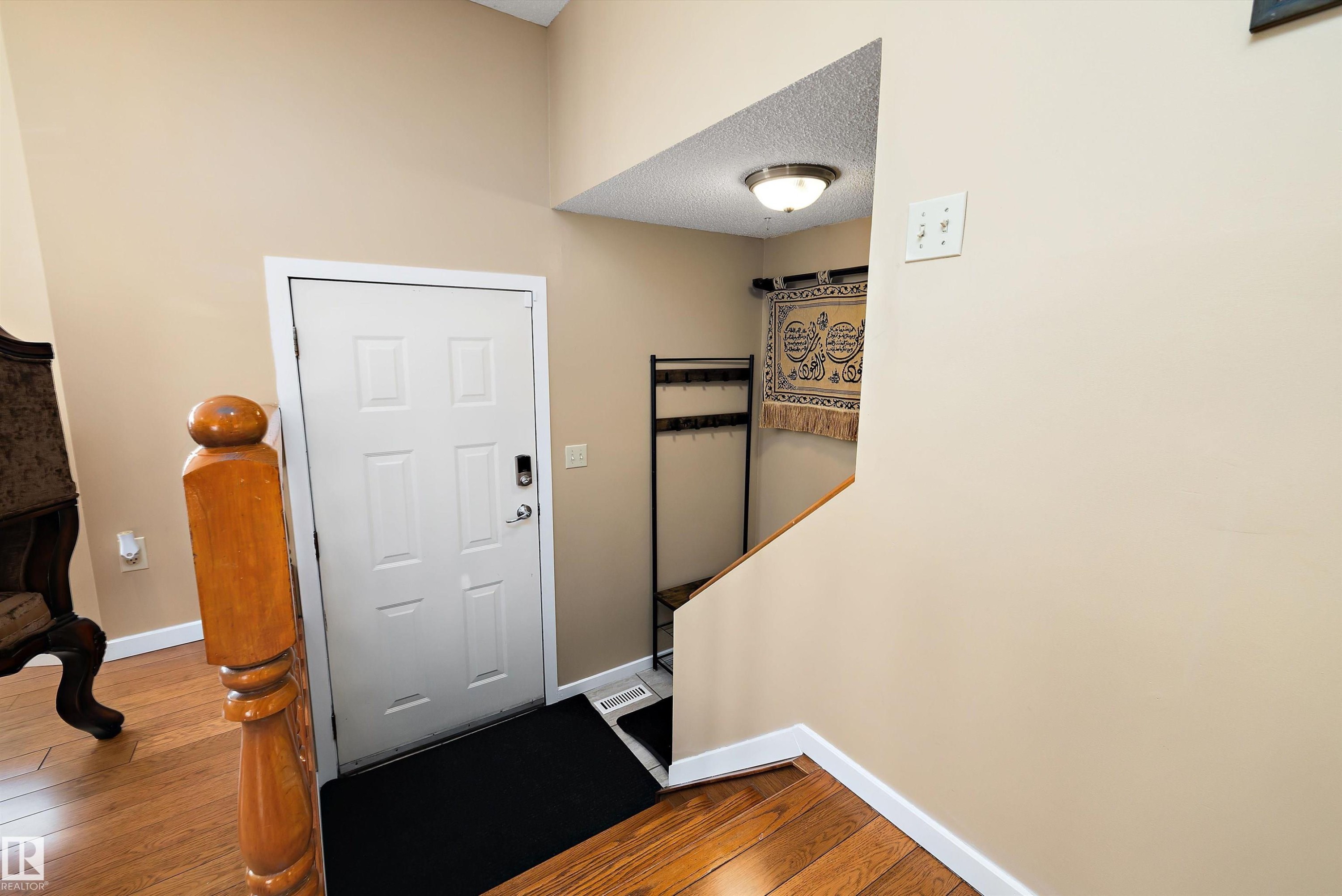 Foyer entrance with dark wood finished floors and baseboards - 9804 156 Avenue, Edmonton, AB - Indoor Photo Showing Other Room