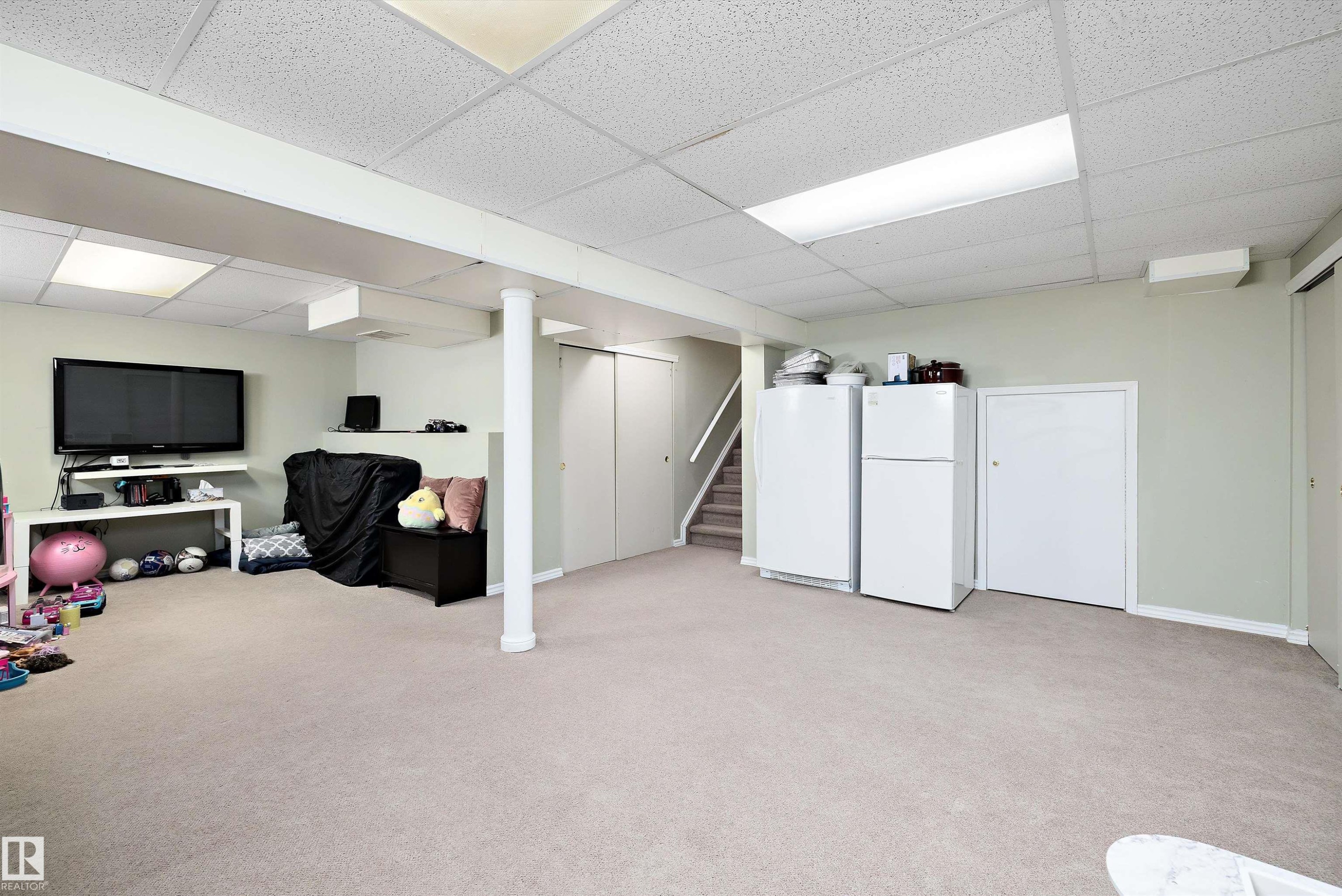 Finished basement with freestanding refrigerator, a paneled ceiling, and light colored carpet - 9804 156 Avenue, Edmonton, AB - Indoor Photo Showing Basement