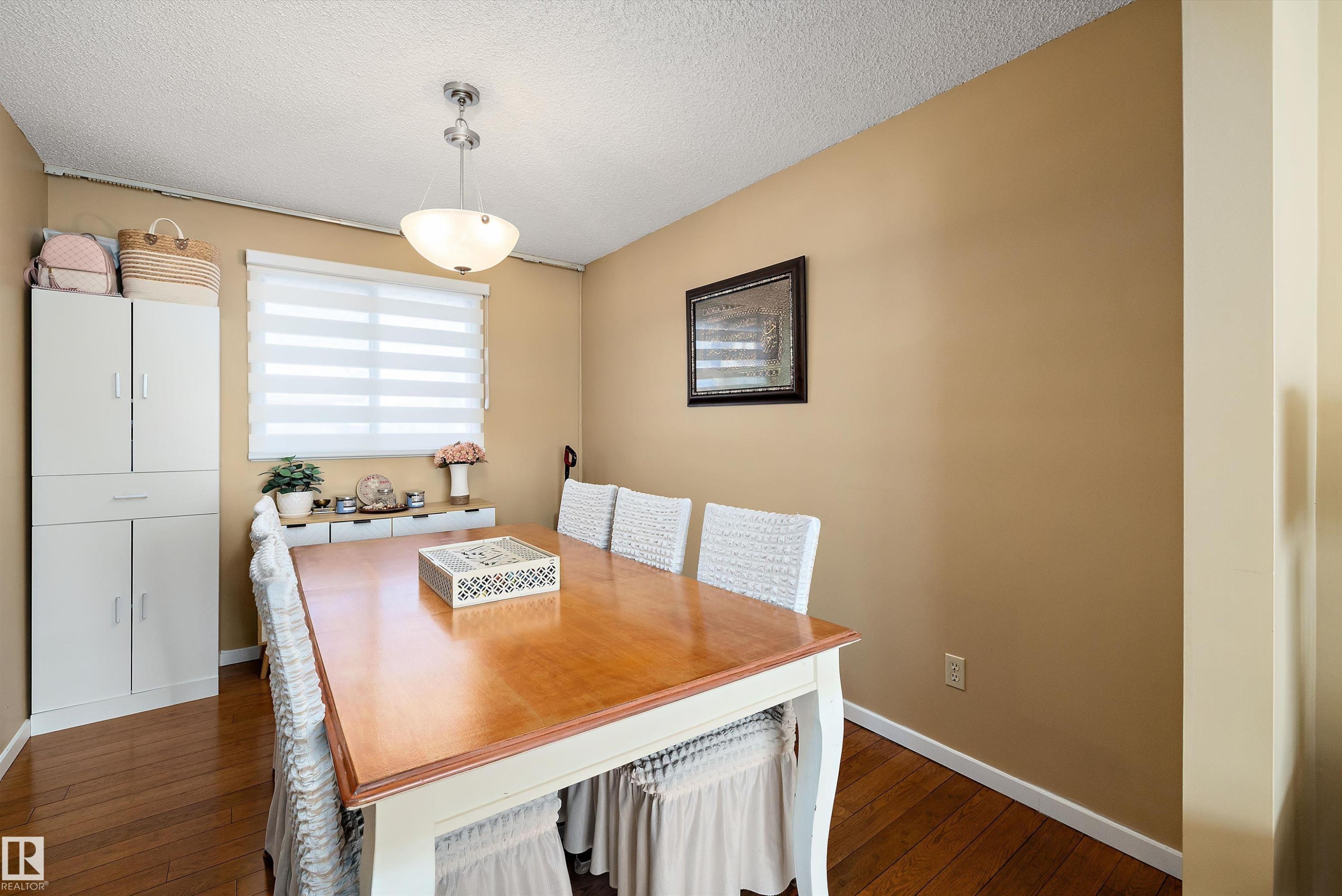 Dining space featuring dark wood-type flooring and a textured ceiling - 9804 156 Avenue, Edmonton, AB - Indoor Photo Showing Dining Room