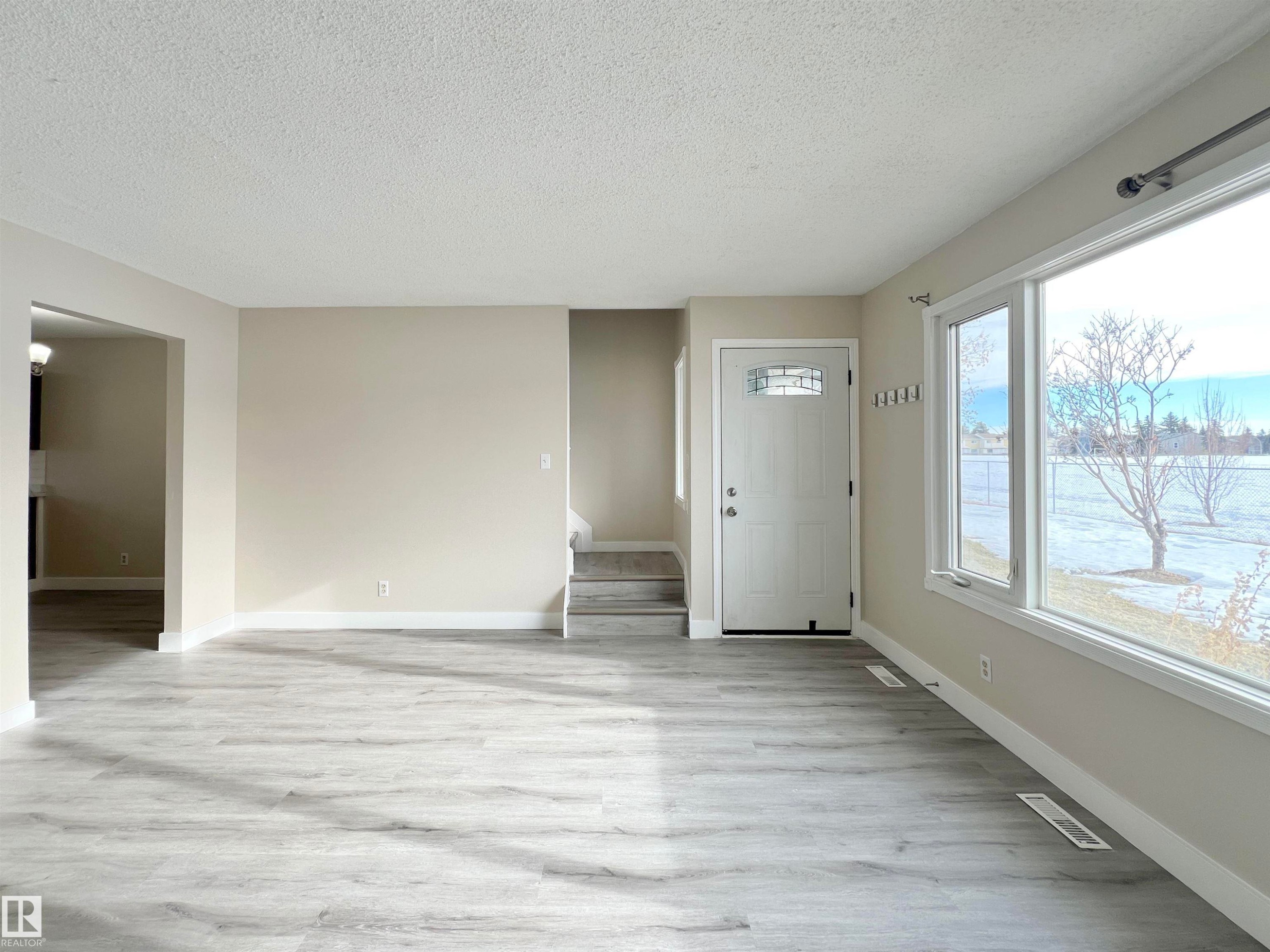Foyer entrance with light wood-style flooring and a textured ceiling - 11357 22 Avenue, Edmonton, AB - Indoor Photo Showing Other Room