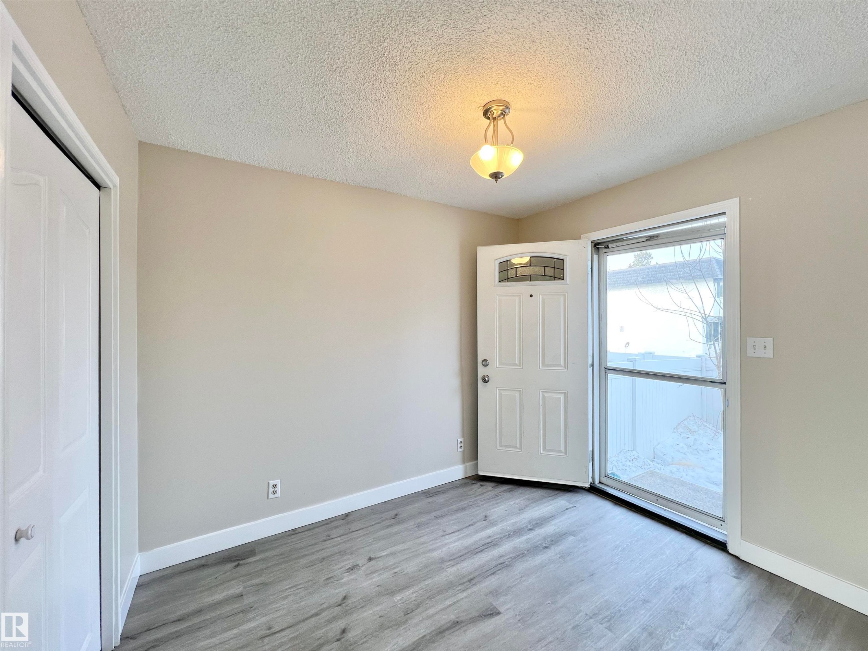 Foyer entrance featuring a textured ceiling and light wood-type flooring - 11357 22 Avenue, Edmonton, AB - Indoor Photo Showing Other Room
