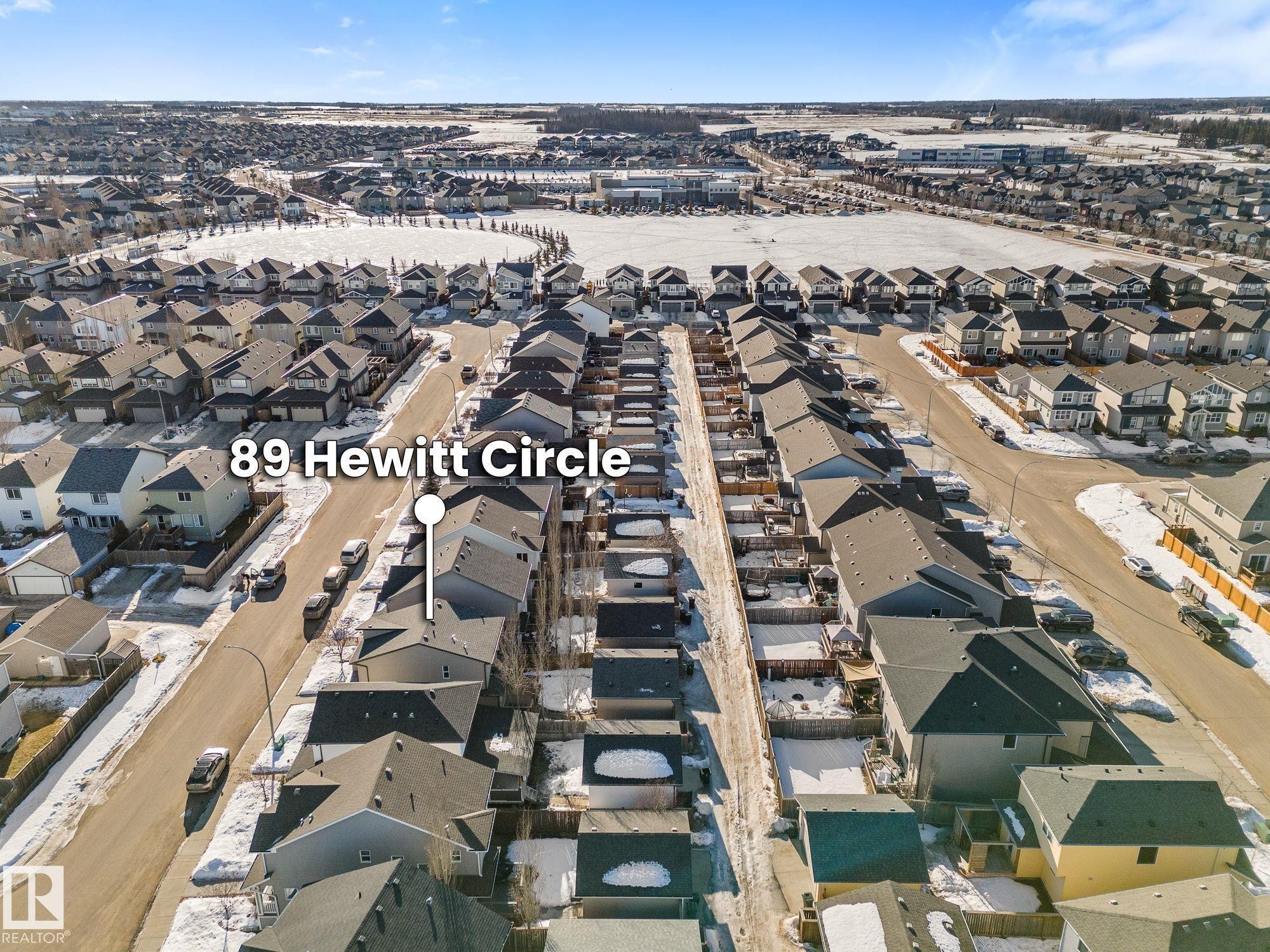 Aerial view of the property's location with nearby green space, ball diamonds, and school (St. Peter the Apostle Catholic High School) - 89 Hewitt Circle, Spruce Grove, AB - Outdoor With View