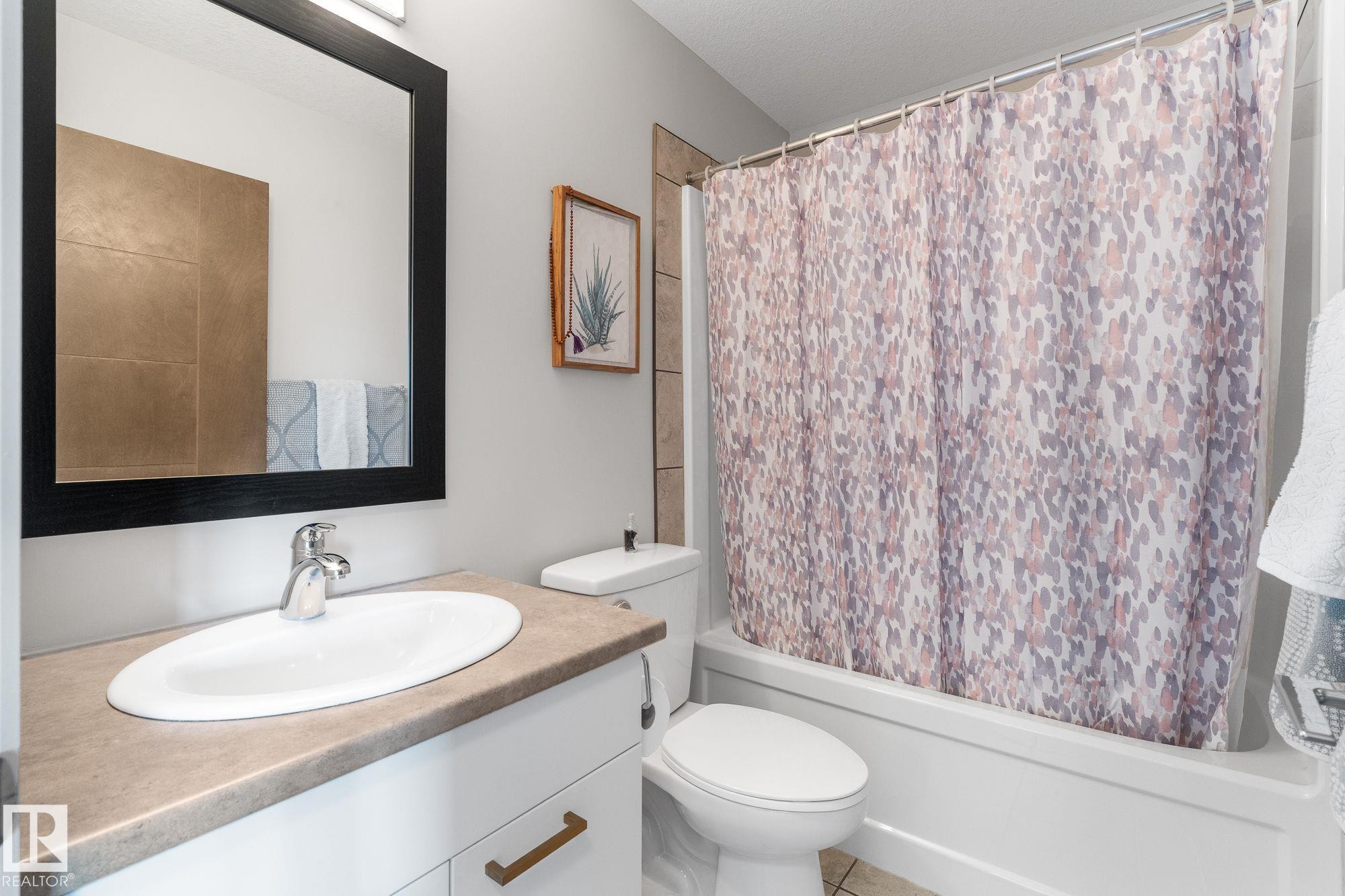 Full bath with vanity, shower / tub combo with curtain, and a textured ceiling - 89 Hewitt Circle, Spruce Grove, AB - Indoor Photo Showing Bathroom