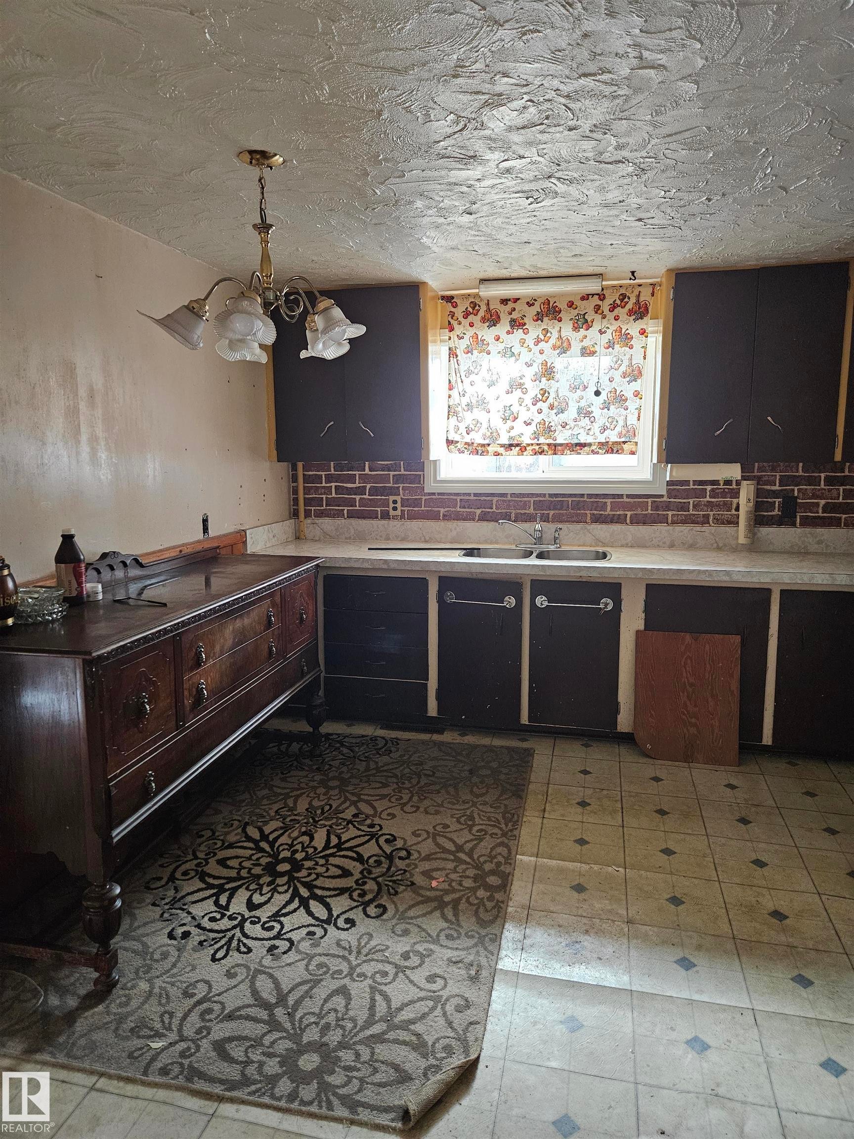 Kitchen featuring light countertops, decorative light fixtures, light floors, and a textured ceiling - 5314 57 Street, Cold Lake, AB - Indoor