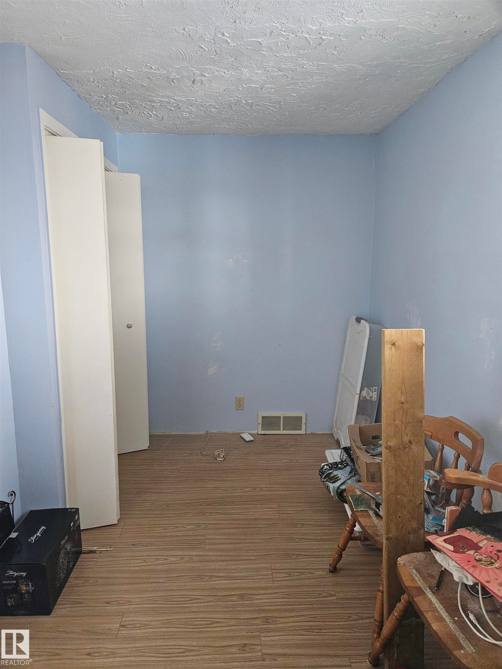 Misc room featuring hardwood / wood-style floors and a textured ceiling - 5314 57 Street, Cold Lake, AB - Indoor Photo Showing Other Room
