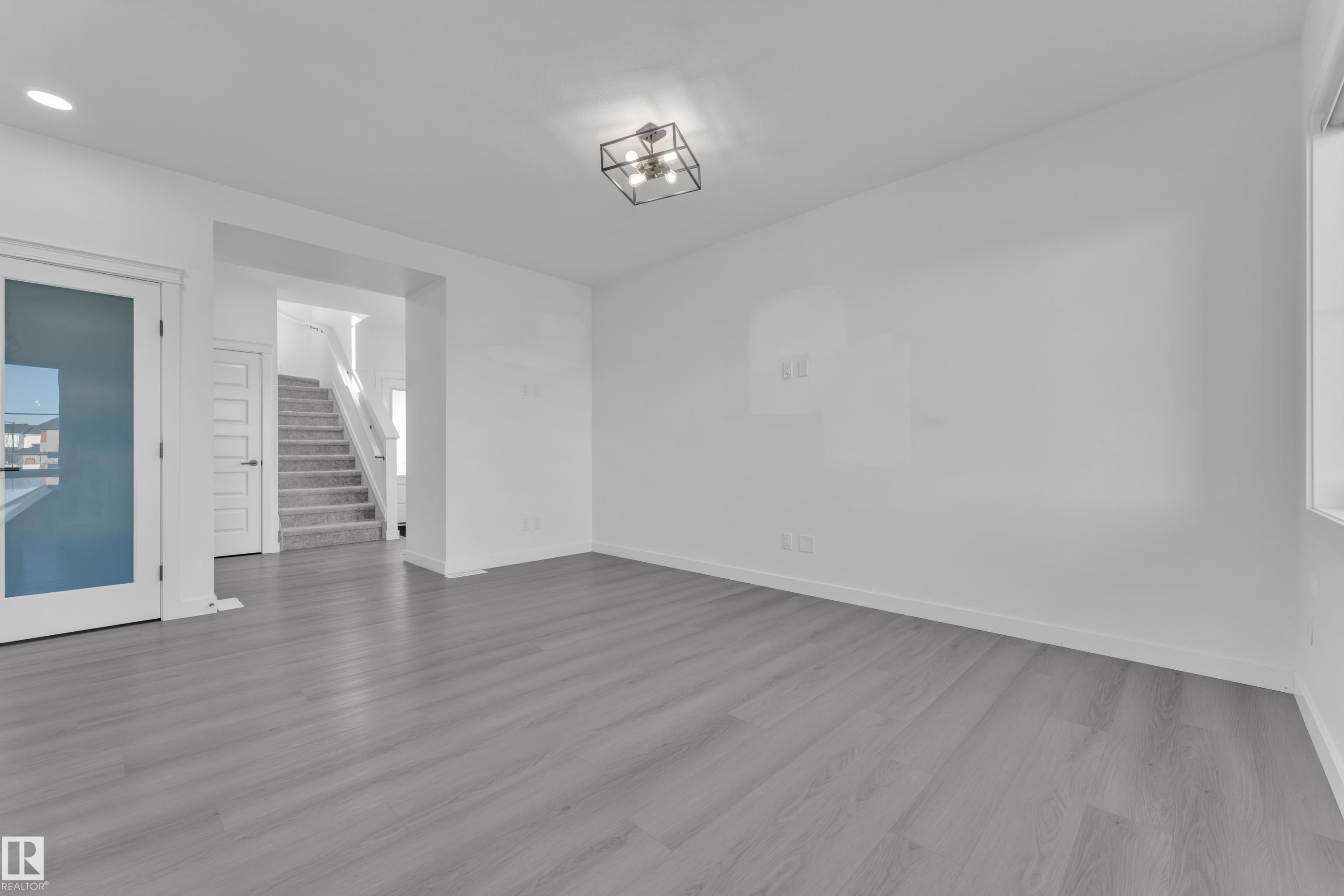 Empty room with stairs and wood finished floors - 1822 Collip View, Edmonton, AB