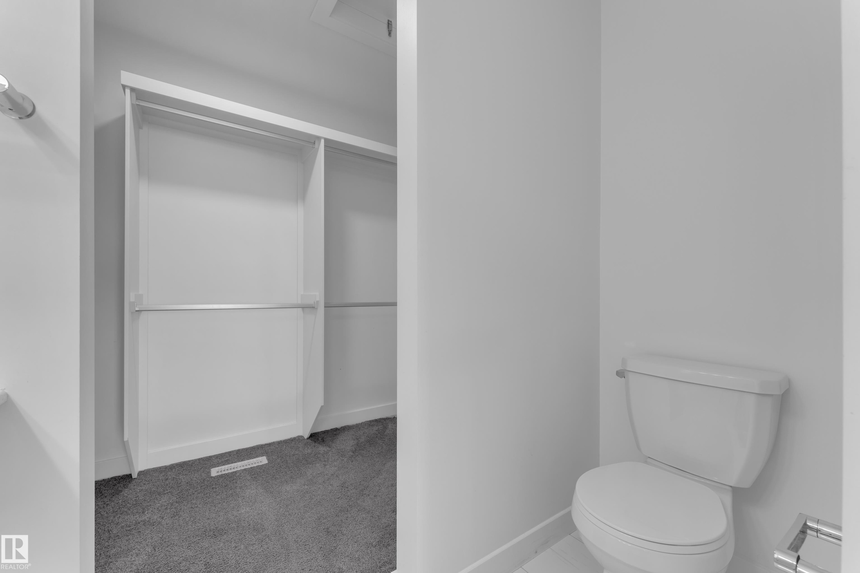 Half bathroom with a spacious closet, light carpet, and baseboard heating - 1822 Collip View, Edmonton, AB