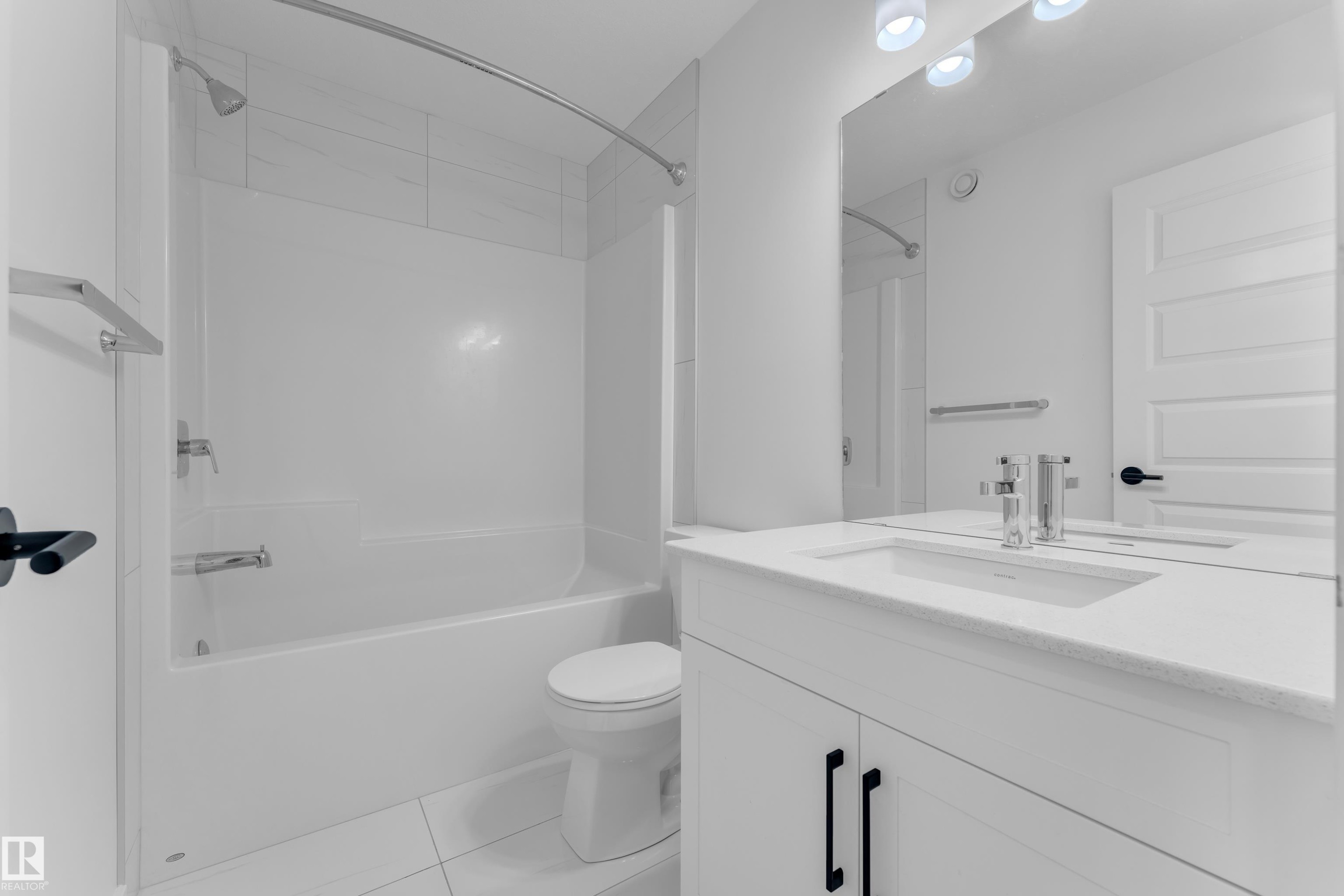 Bathroom featuring vanity, bathing tub / shower combination, and light tile patterned flooring - 1822 Collip View, Edmonton, AB