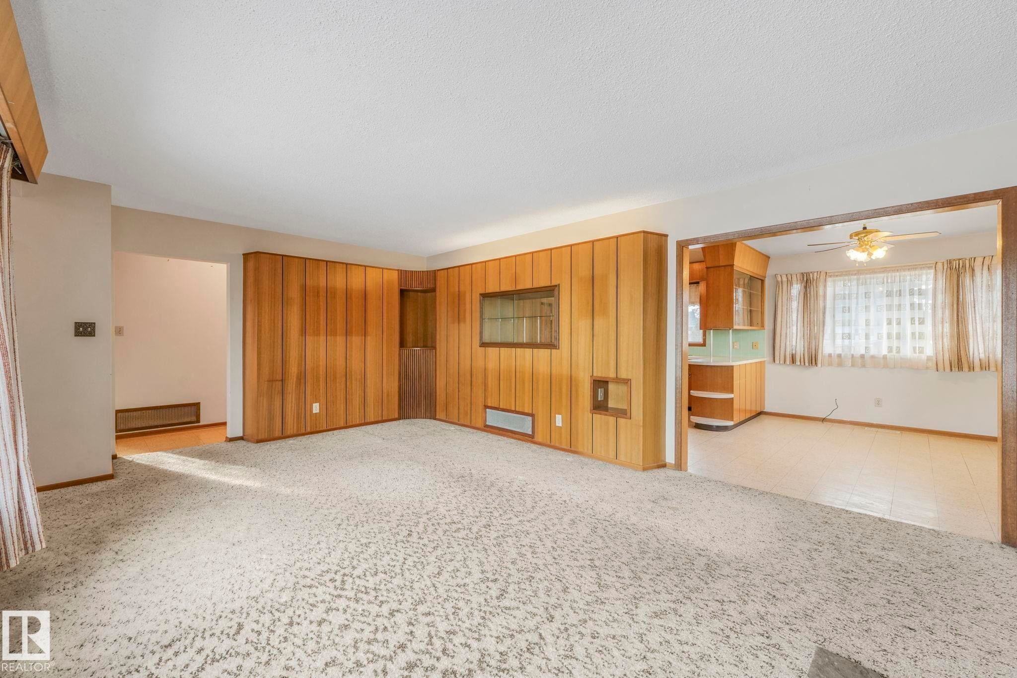 Unfurnished living room with light colored carpet, ceiling fan, and a textured ceiling - 10324 42 Street, Edmonton, AB - Indoor Photo Showing Other Room
