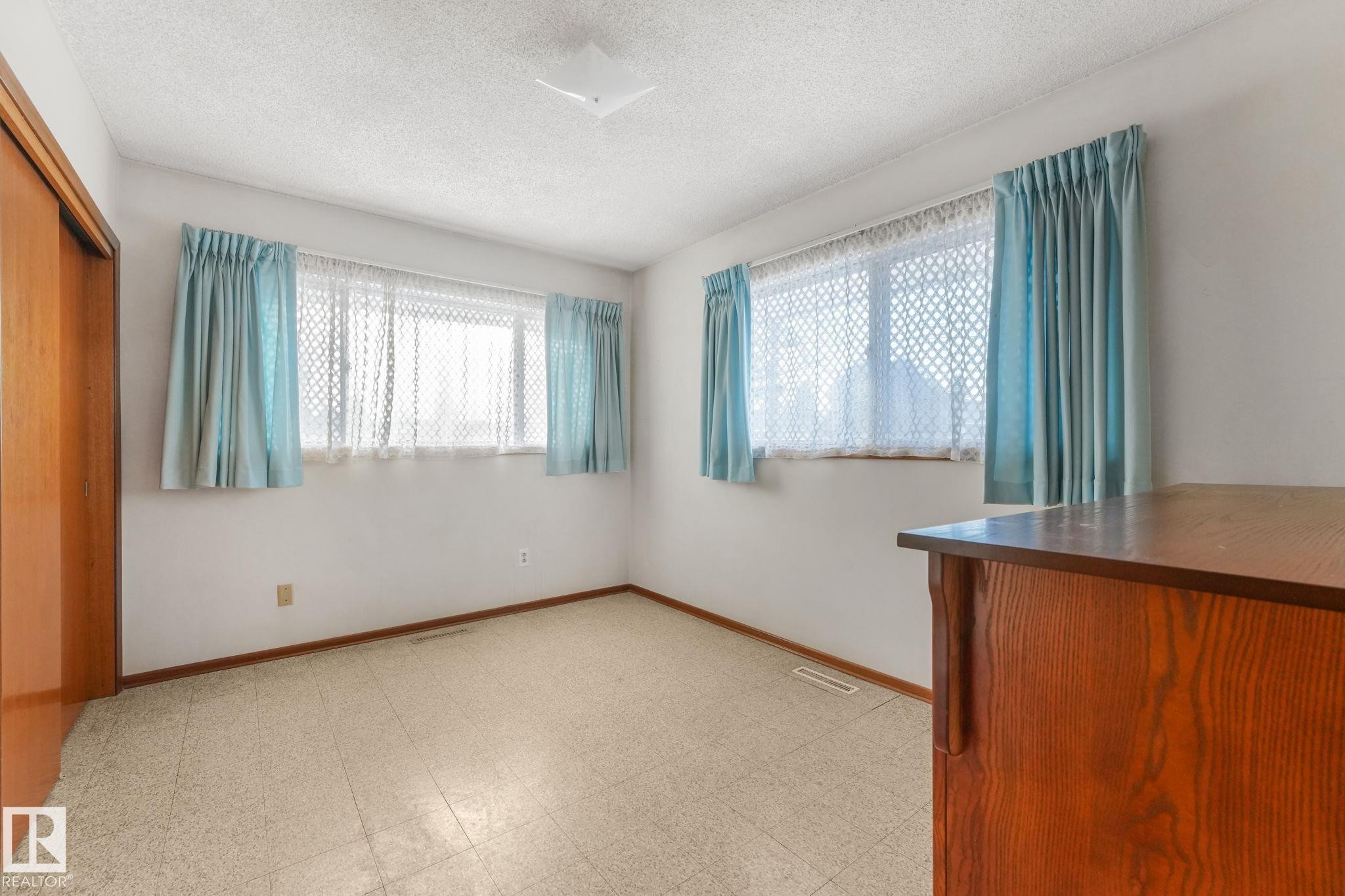 Unfurnished bedroom with light flooring, a closet, multiple windows, and a textured ceiling - 10324 42 Street, Edmonton, AB - Indoor Photo Showing Other Room