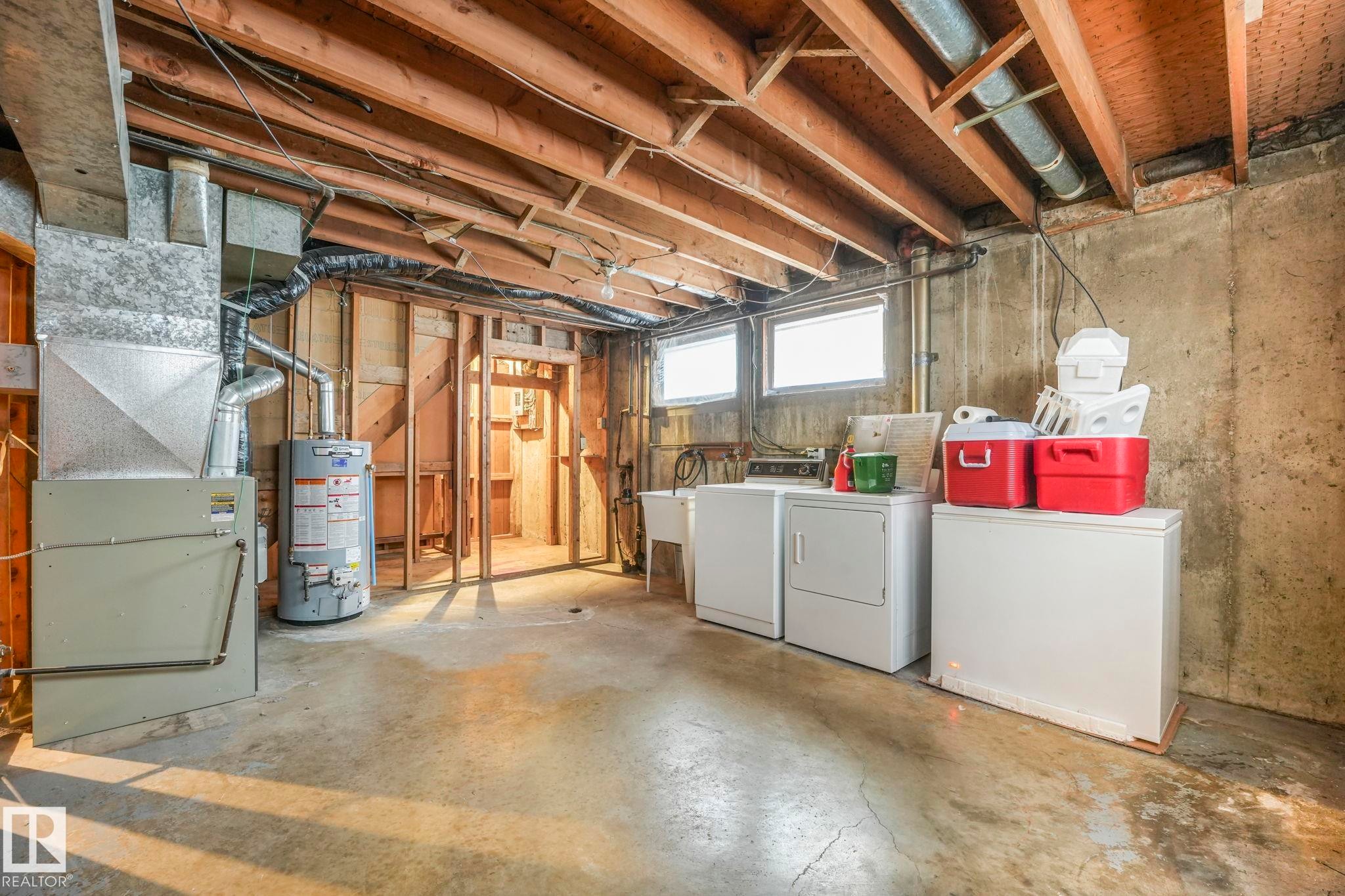Basement featuring separate washer and dryer, water heater, and heating unit - 10324 42 Street, Edmonton, AB - Indoor Photo Showing Laundry Room